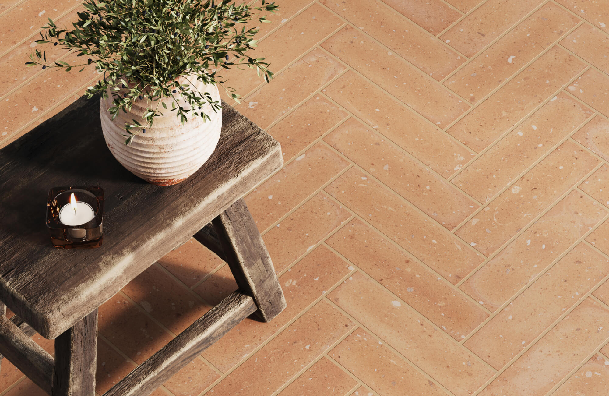 Warm terracotta tiles in a herringbone pattern, paired with natural decor elements for a cozy, handcrafted look.