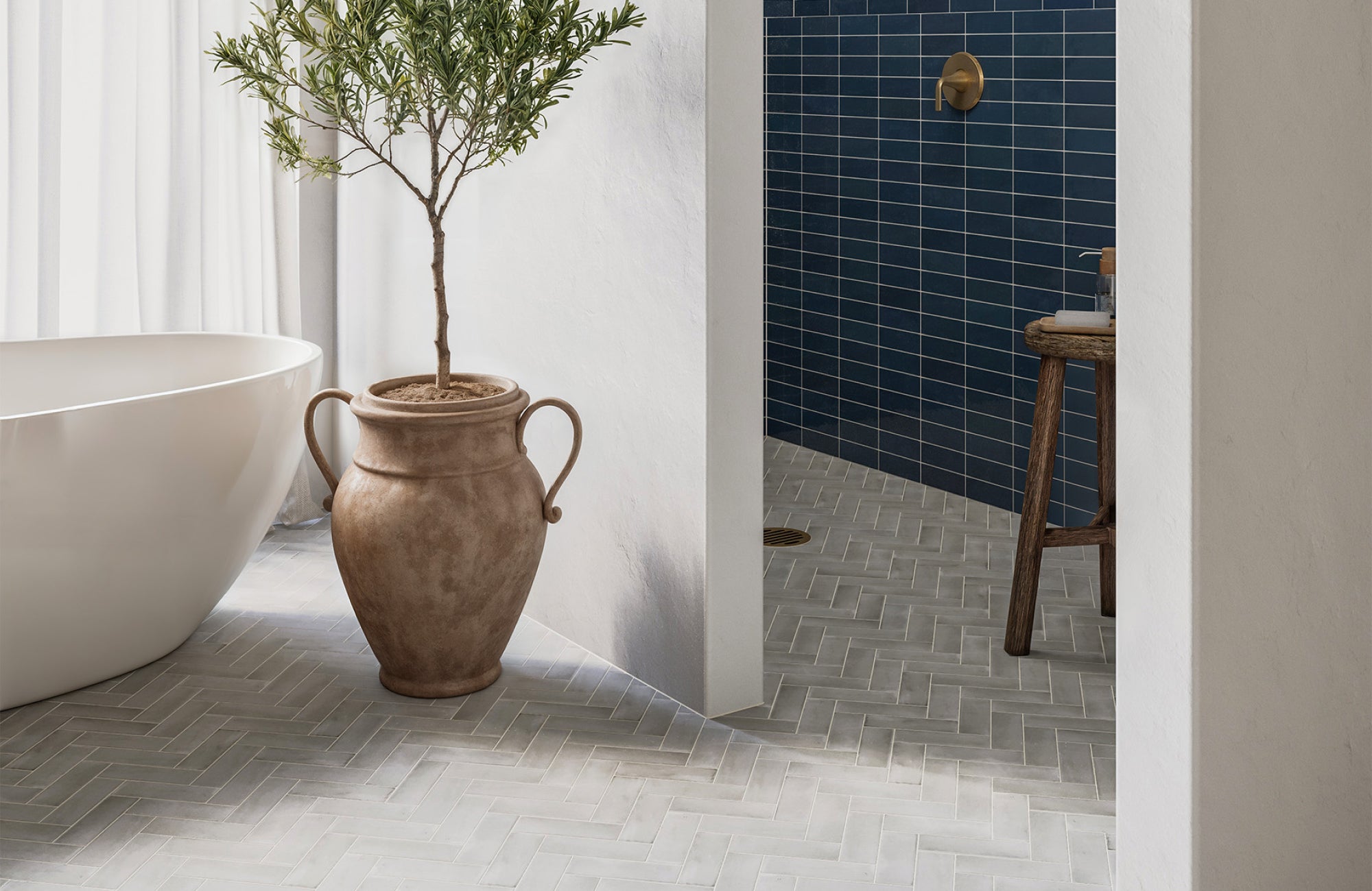 null Neutral bathroom floor with herringbone tile pattern complementing white walls and modern finishes.