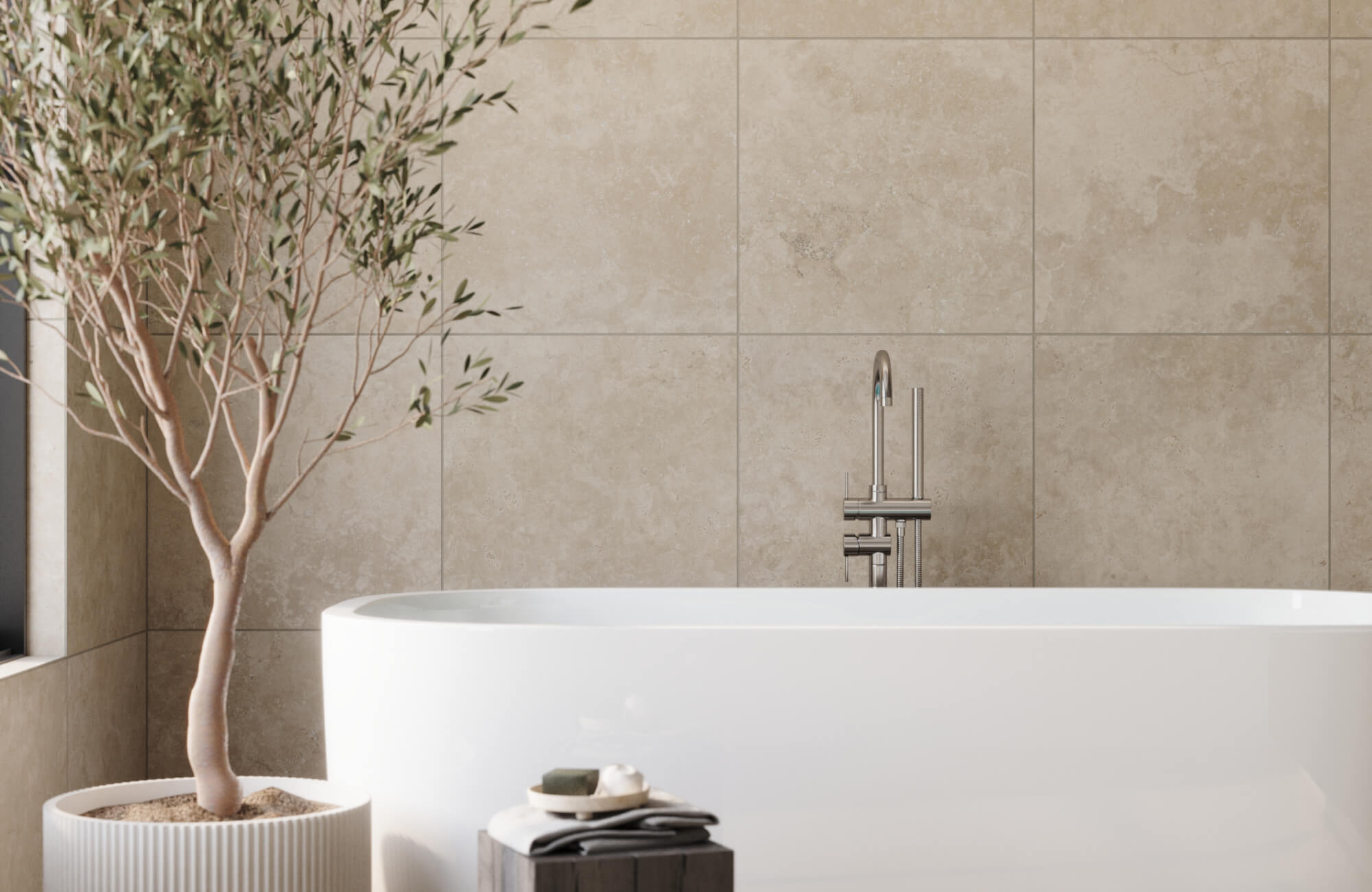 Large format tile in small bathroom with beige stone-look wall tiles behind freestanding tub, creating a spacious, spa-like atmosphere with minimal visual breaks.