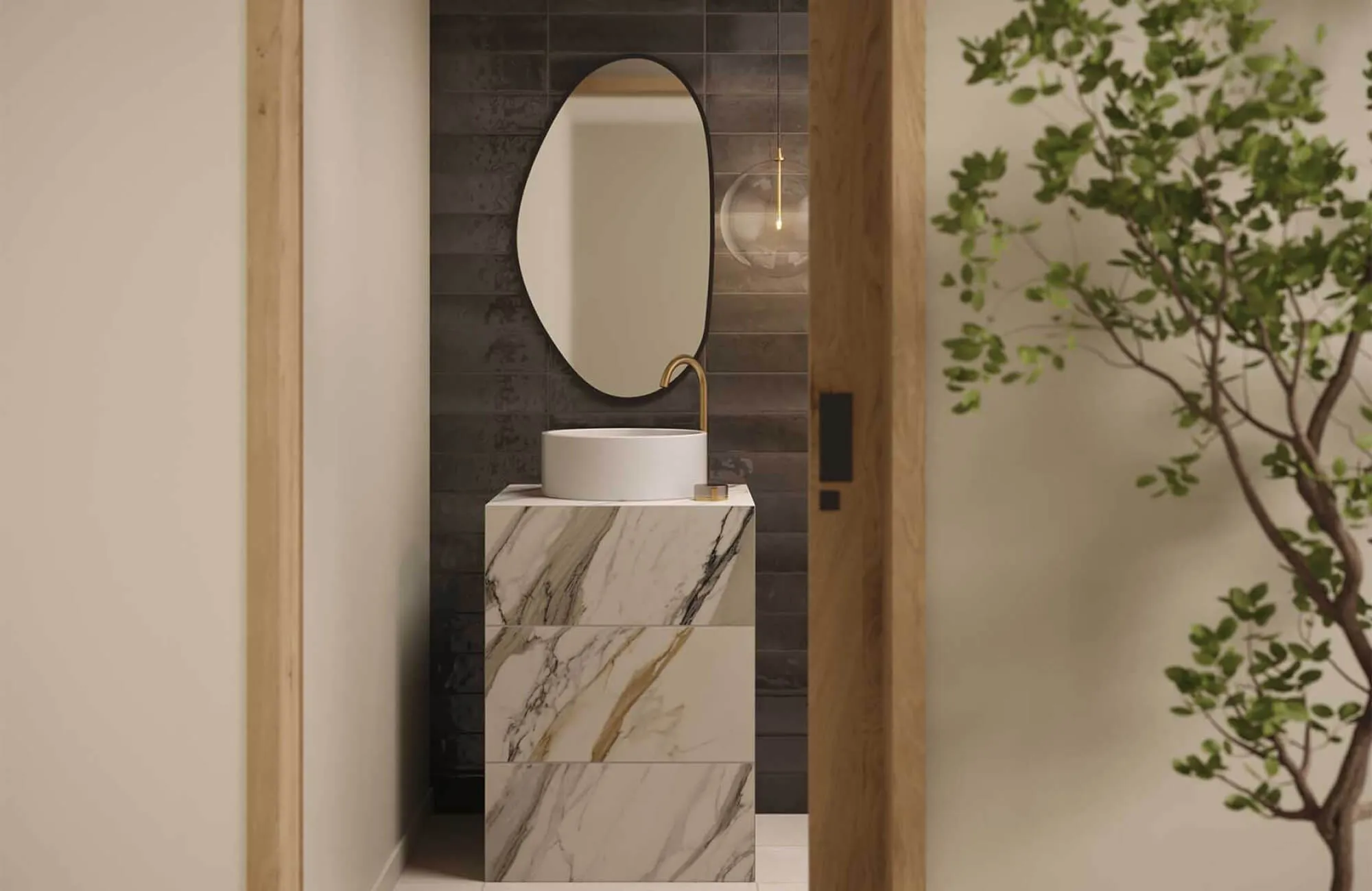 Modern bathroom featuring a marble look tile vanity, paired with a round mirror and brass faucet against a subtly textured dark backdrop.
