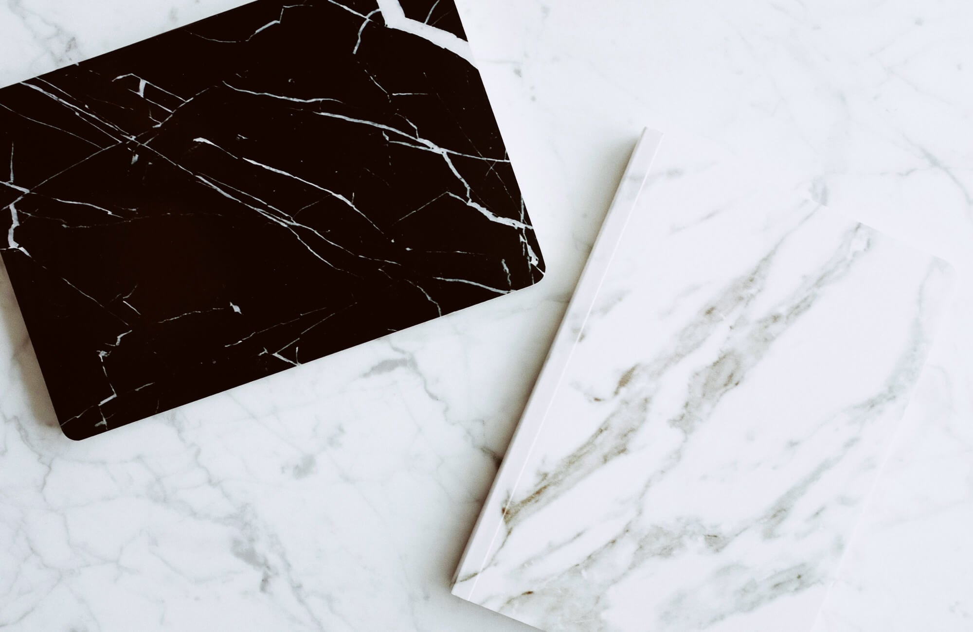 null Marble surfaces in black and white with natural veining, placed side by side to highlight contrast in tone and pattern.