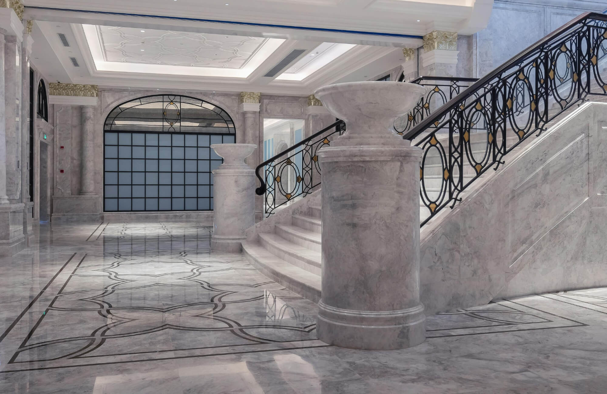 null Grand interior with marble flooring and staircase, where soft gray veining flows across the space and highlights its refined, architectural details.