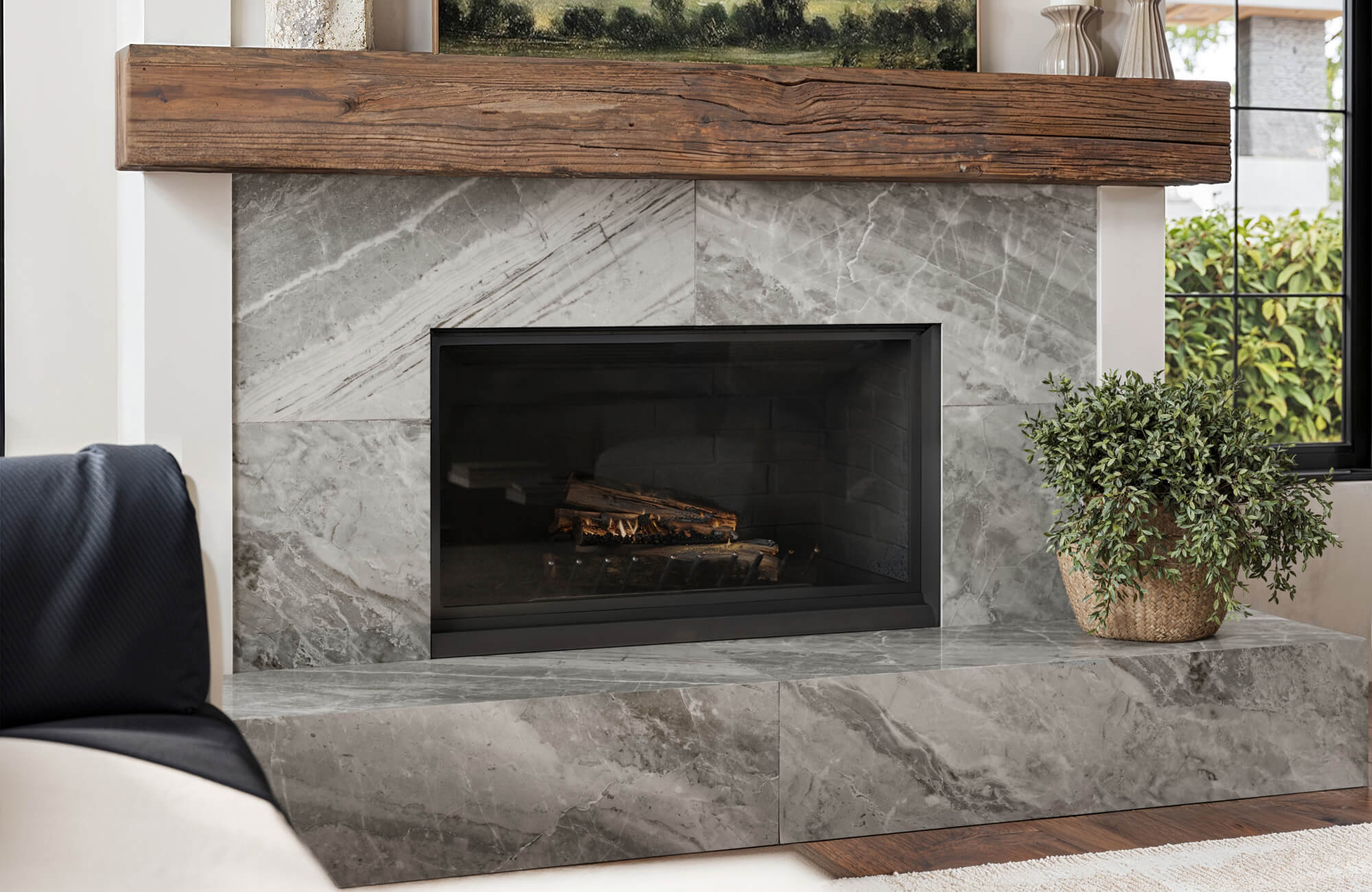 null Living space featuring a marble look tile fireplace, with layered gray veining that adds depth beneath a natural wood mantel.