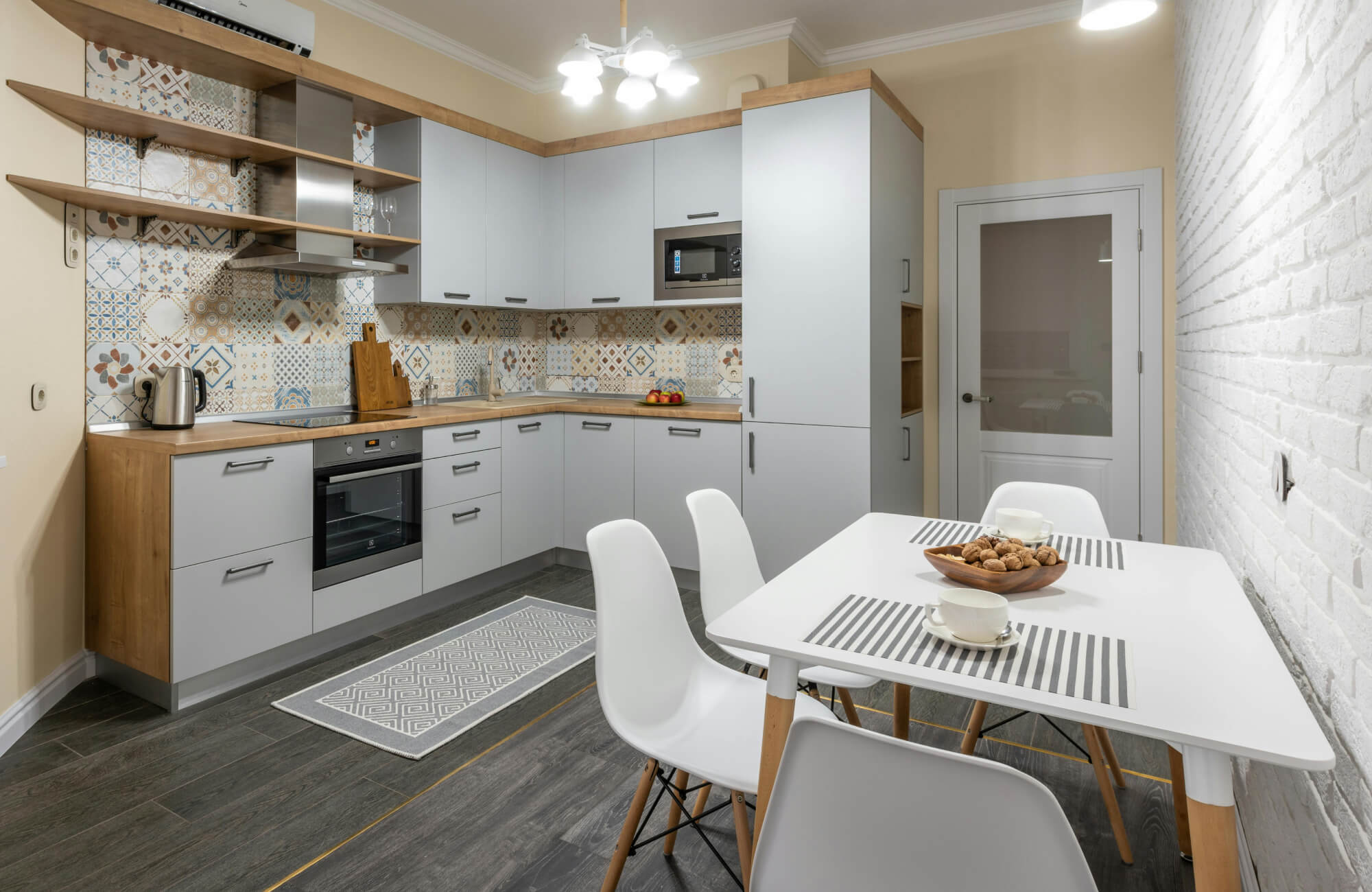 null Light gray kitchen featuring mixed Moroccan-pattern backsplash tiles that create a colorful, eclectic focal point.