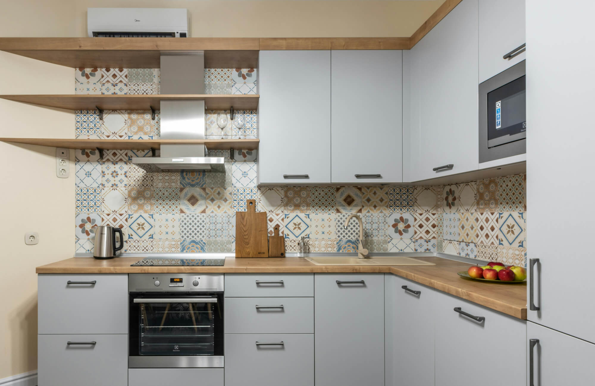 null Modern kitchen showcasing a patchwork Moroccan-pattern backsplash that adds decorative detail to light cabinetry.