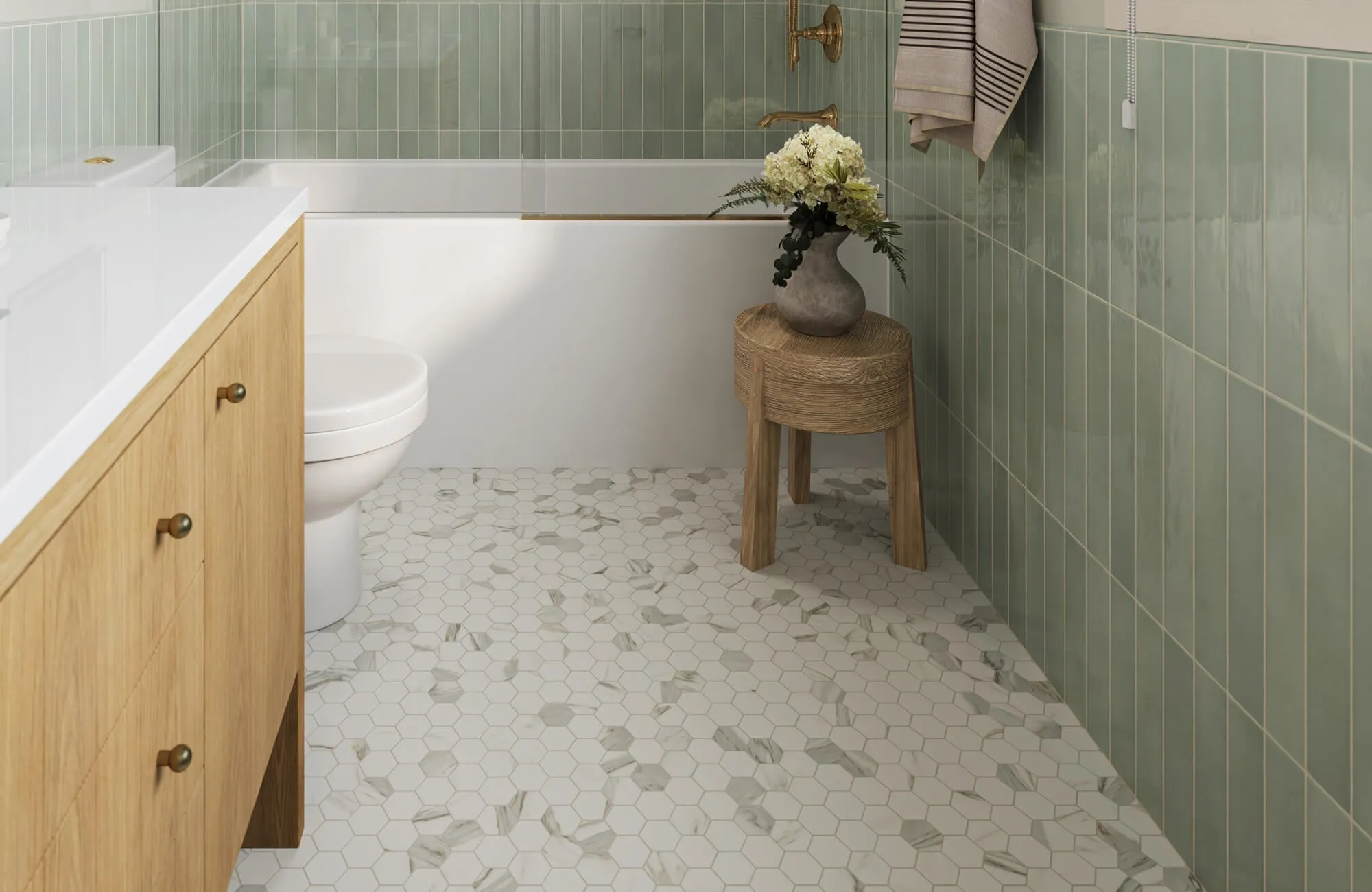 Elegant bathroom with white mosaic hexagonal floor tiles accented by marble-look insets, paired with glossy sage green wall tiles.