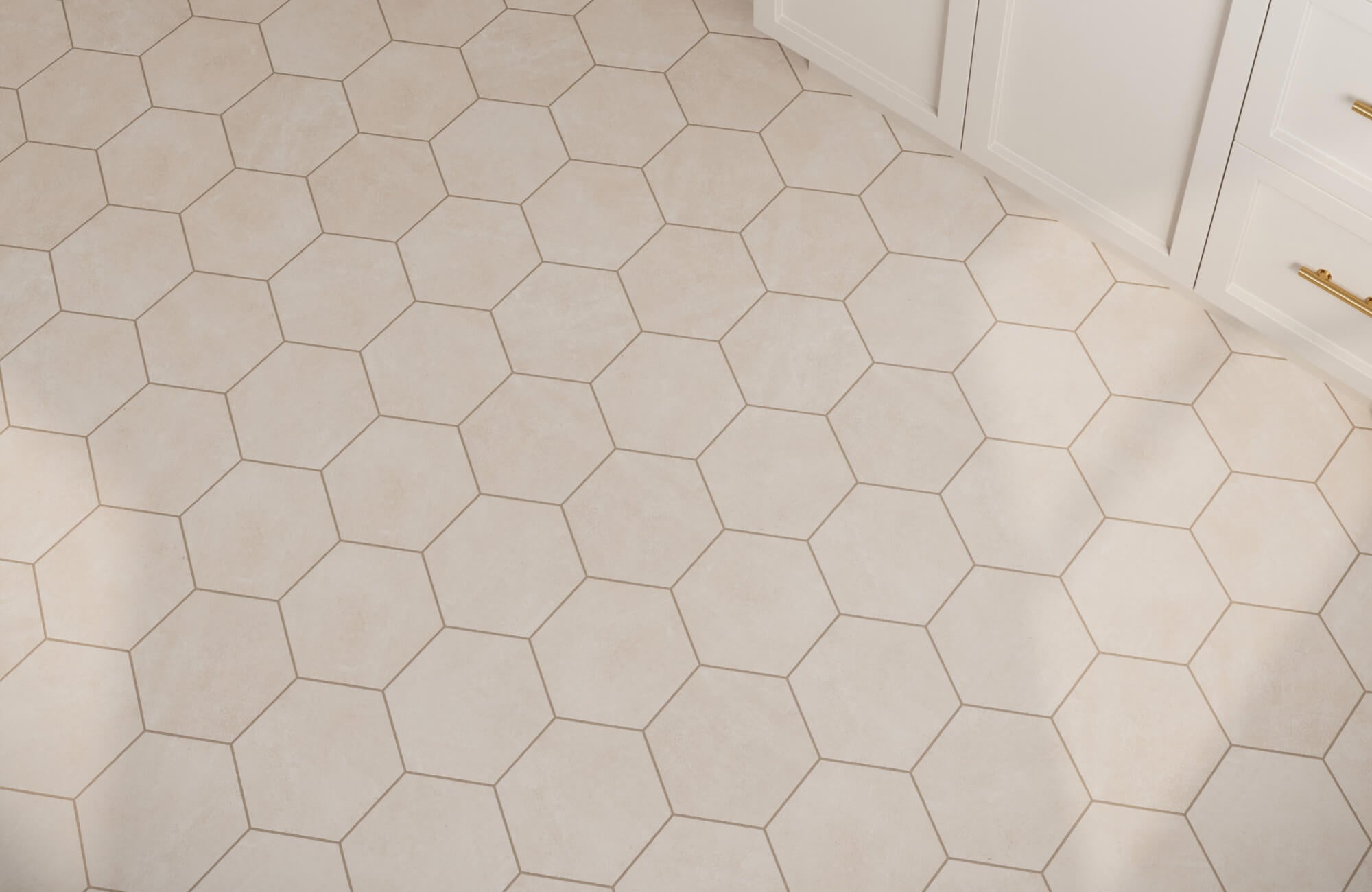 Matte porcelain hexagonal floor tiles in soft beige, creating a modern honeycomb pattern beside sleek white cabinetry.
