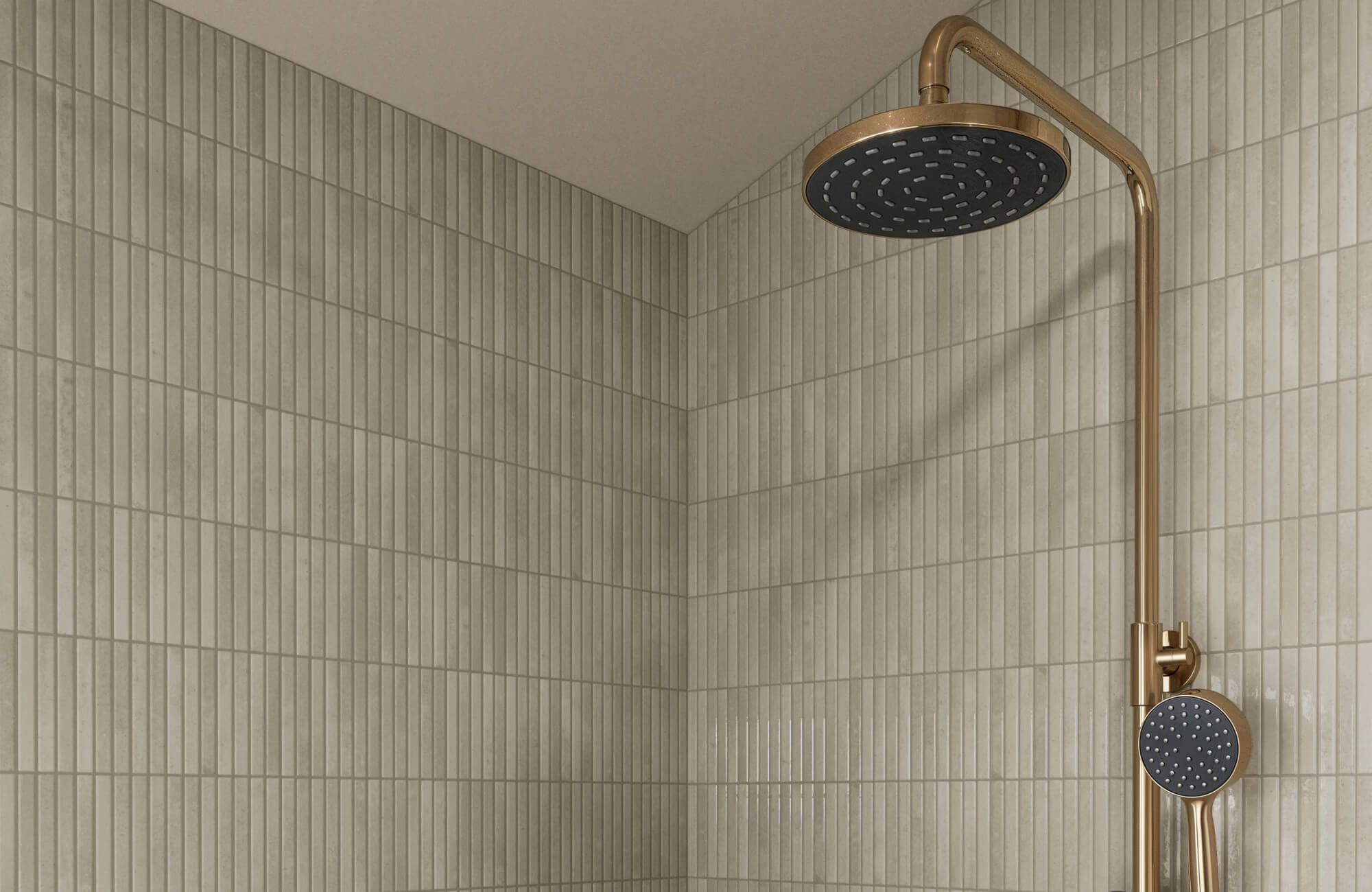 Slim porcelain subway shower tiles in muted taupe with a matte finish, paired with a sleek brass rain shower fixture.