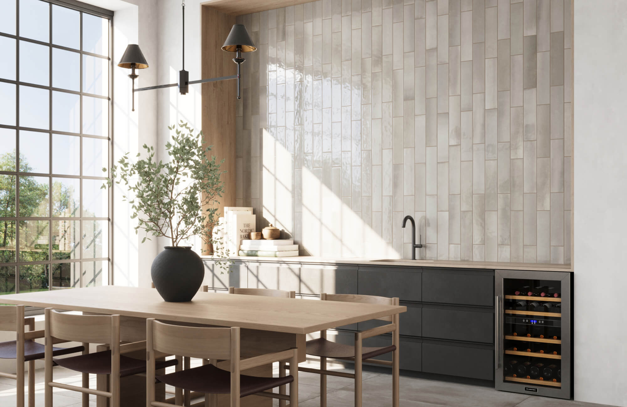 Modern dining and kitchenette area with vertical glossy beige subway tiles, black faucet, light wood table, and large industrial-style windows.