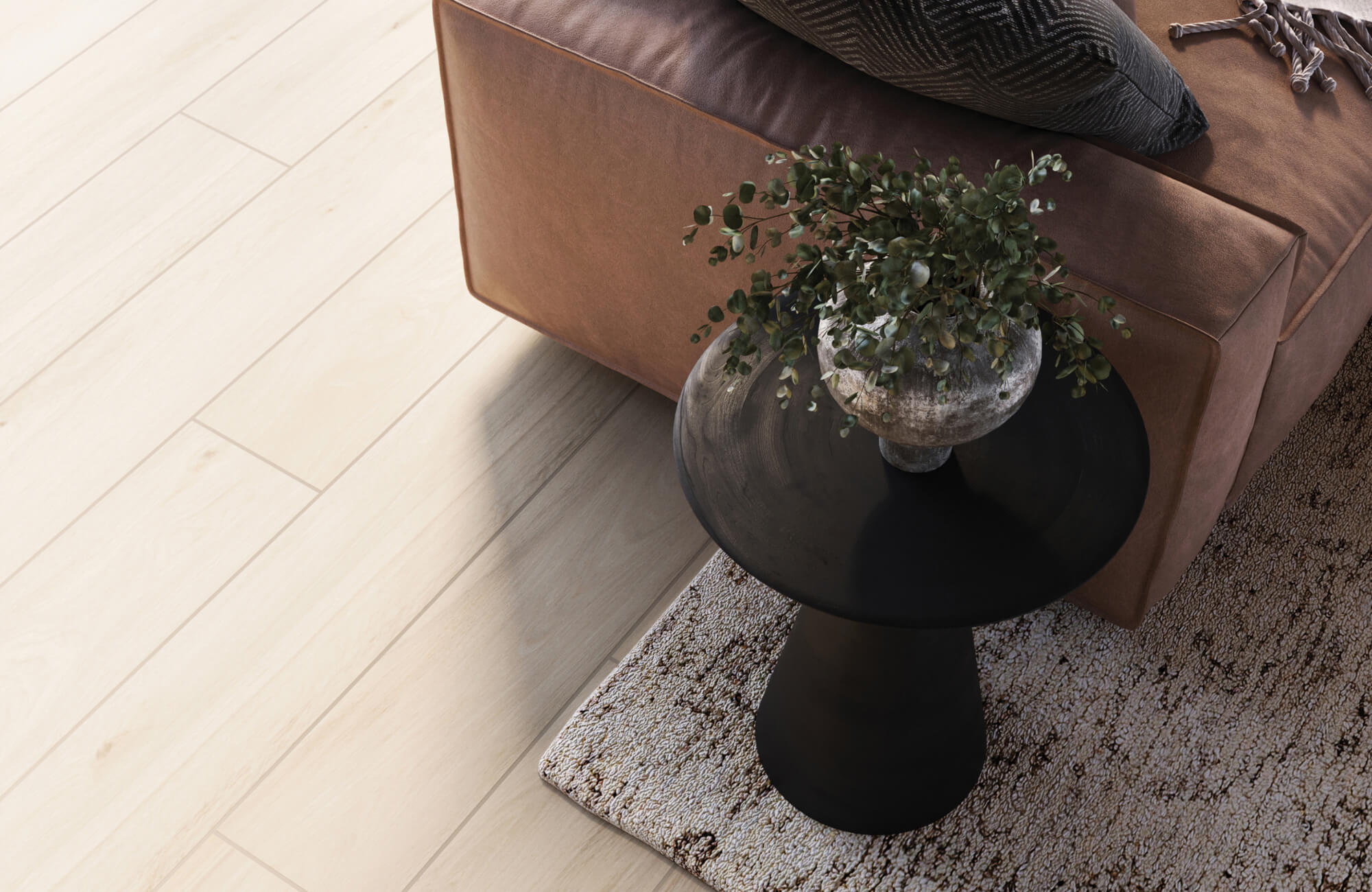 Living room corner with light wood look tile flooring, a brown leather sofa, black round side table, and textured neutral area rug.