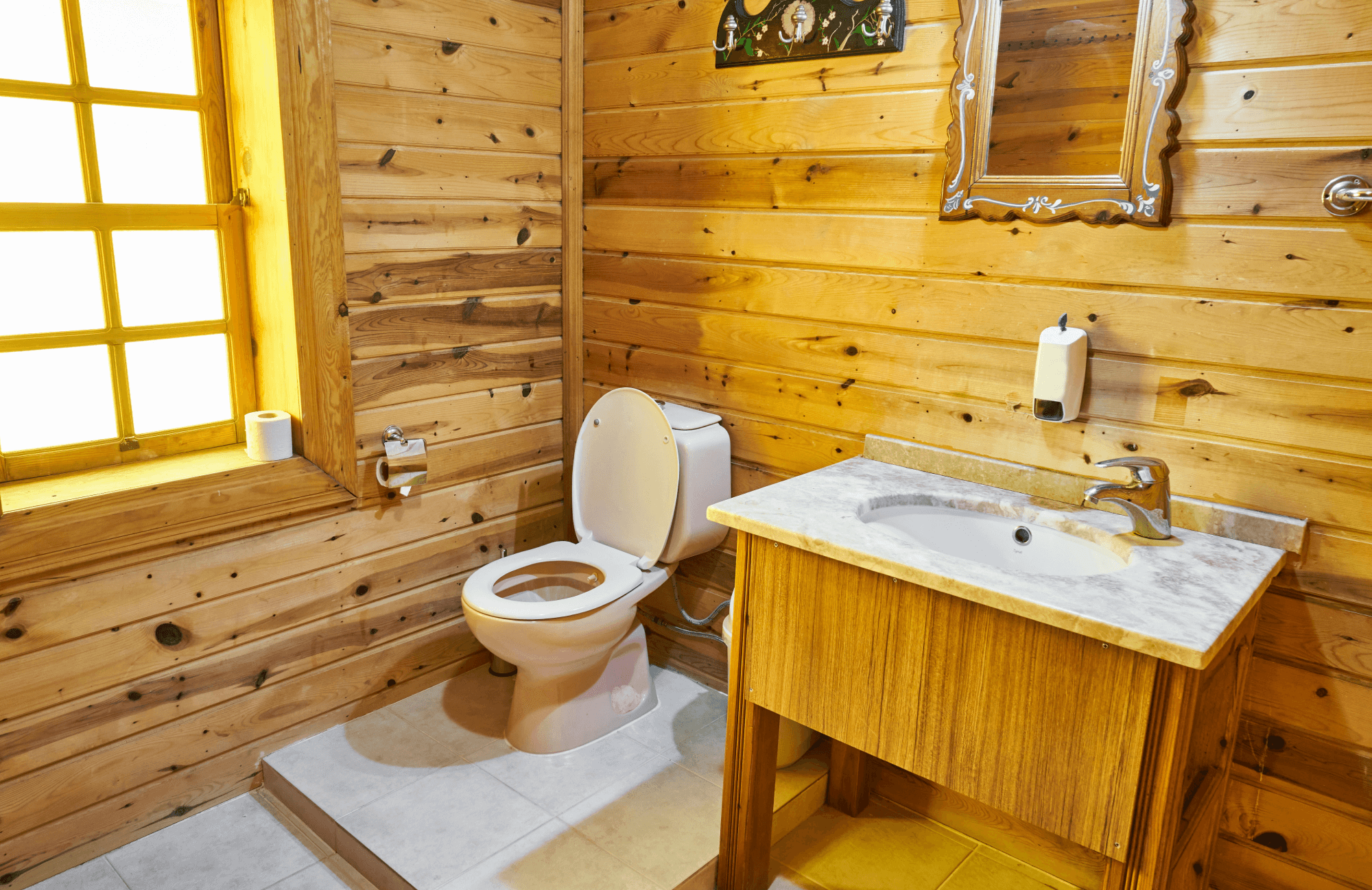 null Rustic bathroom with light wood panel walls, a marble-top vanity, and warm lighting, blending natural charm with functional design.