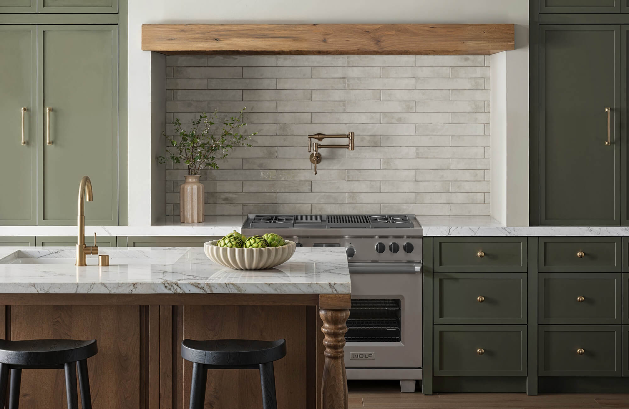 null Elegant kitchen with sage green cabinetry, marble countertops, and a subway tile backsplash, complemented by wooden accents and brass fixtures.
