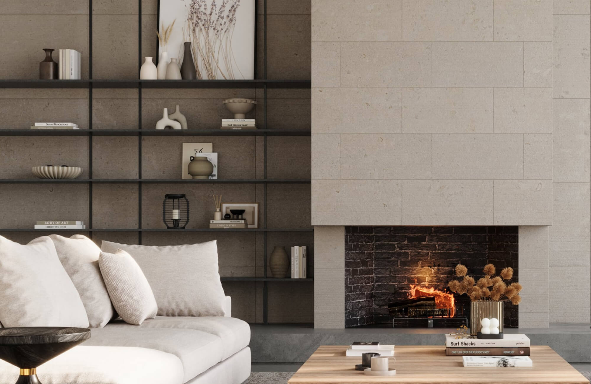 null Modern ceramic sculptures and vessels are arranged on open black shelving beside a stone fireplace in a neutral living room with a wood coffee table.