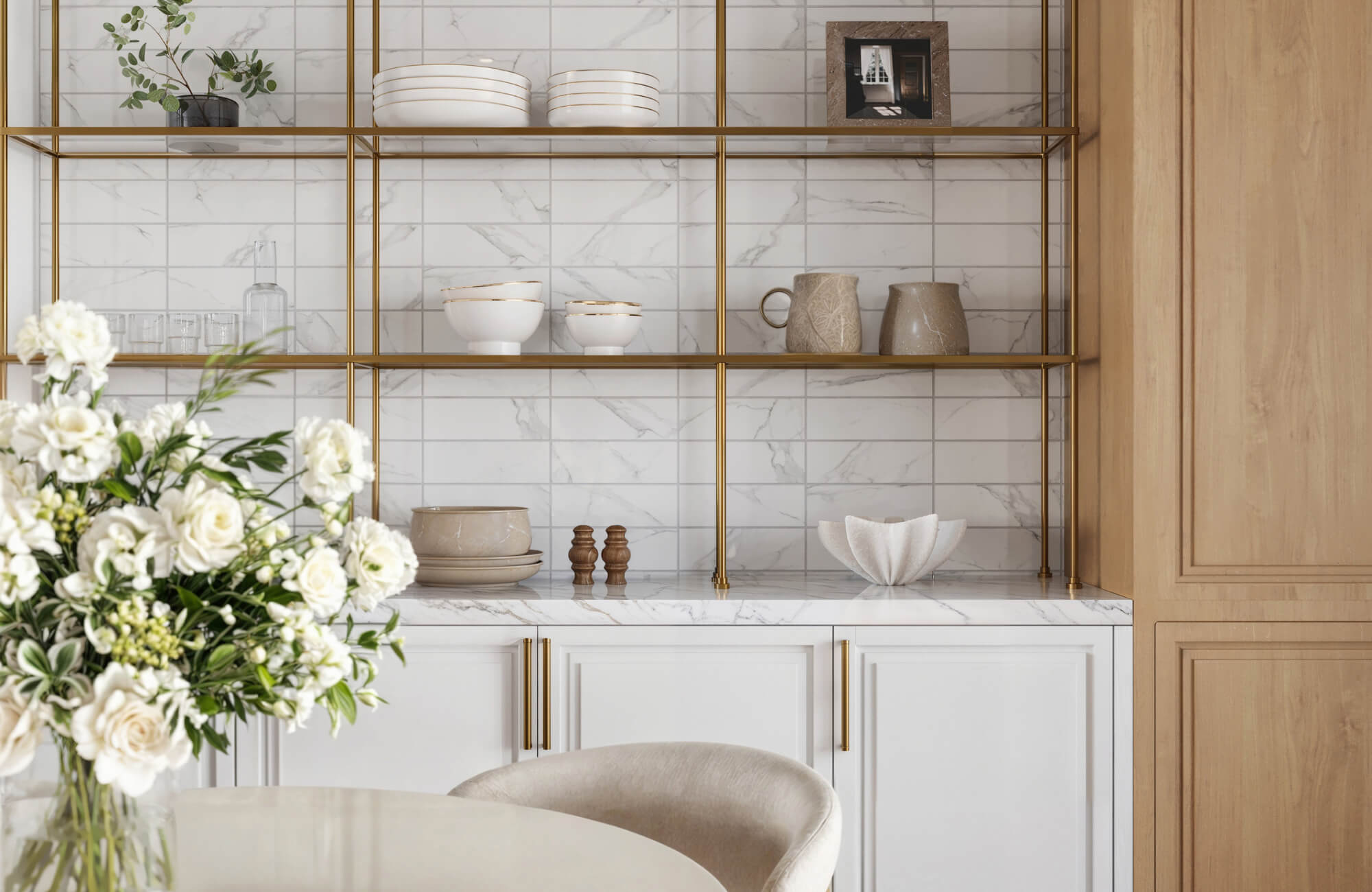 null Elegant kitchen shelving with gold frames, marble-look tile backsplash, white cabinetry, and neutral-toned ceramics and floral accents.