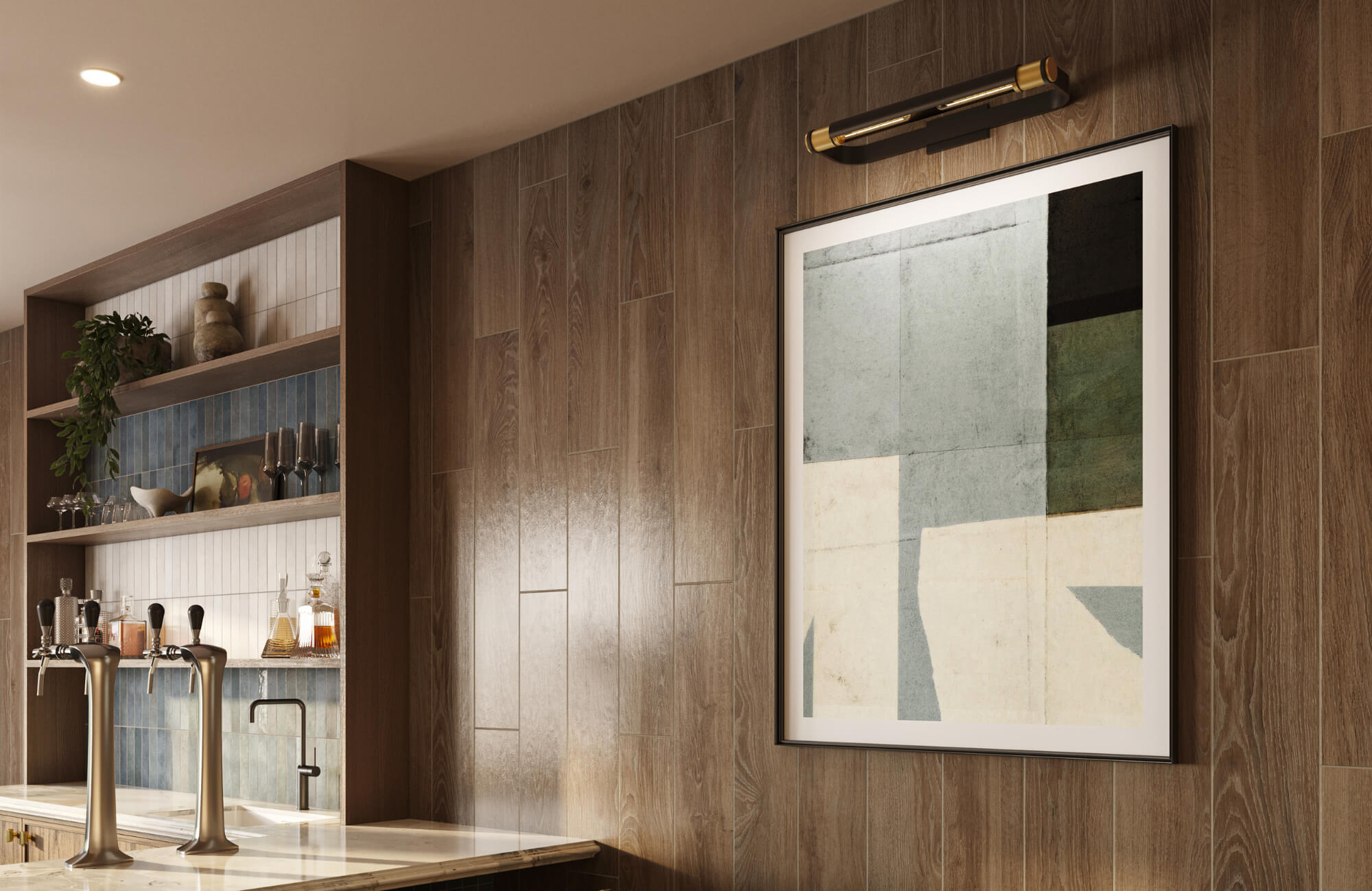 null A contemporary bar area featuring framed abstract artwork lit by a dark brass picture light against warm wood-paneled walls.