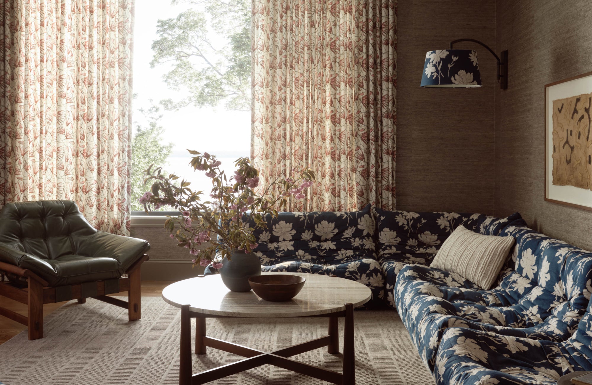 Rug mirrors the wall tone to let the bold floral sofa pop, showcasing how rugs can highlight standout furniture.