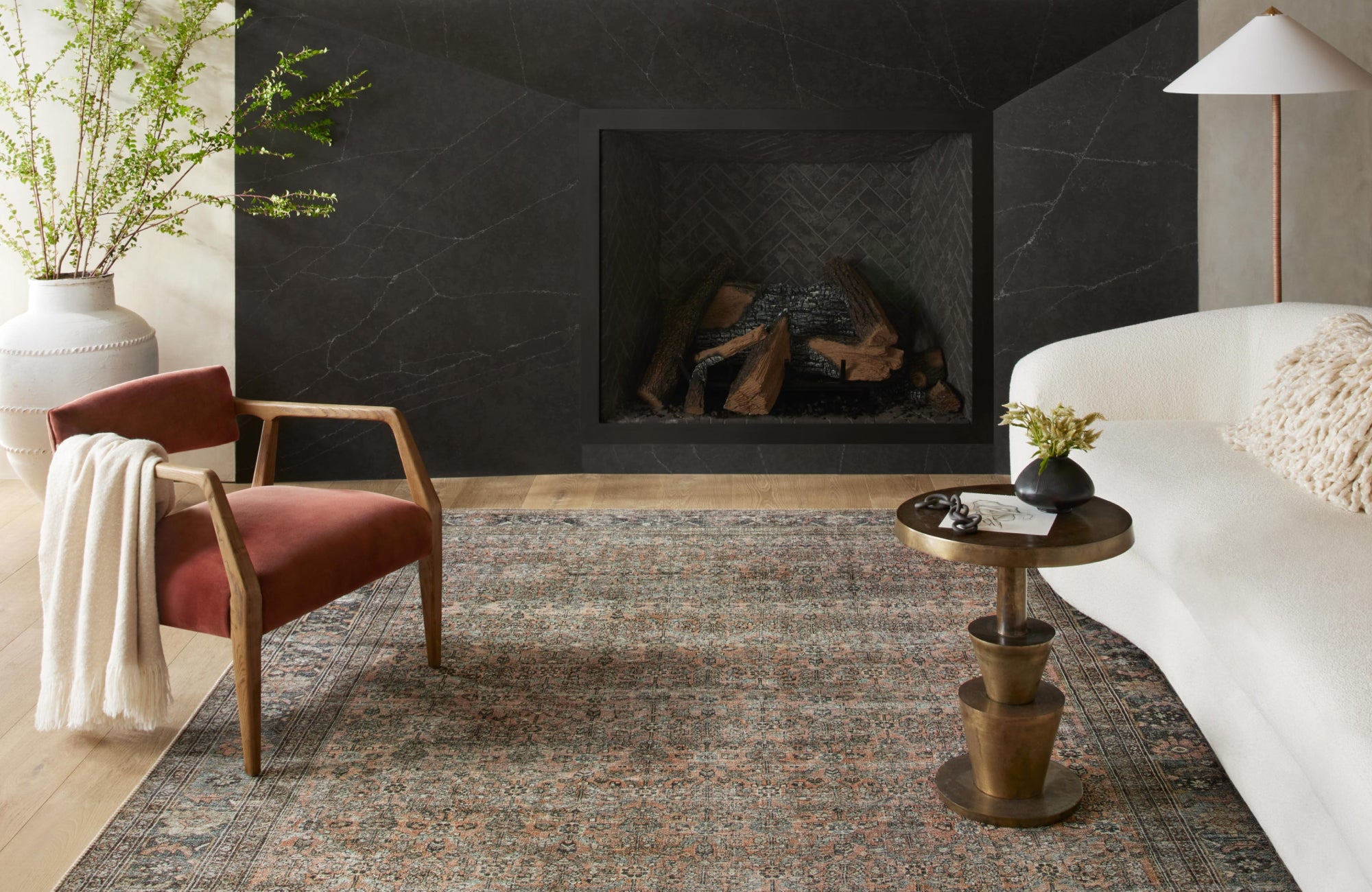 Rich patterned rug contrasts with white sofa and beige walls, making the rug a bold focal point in the room.