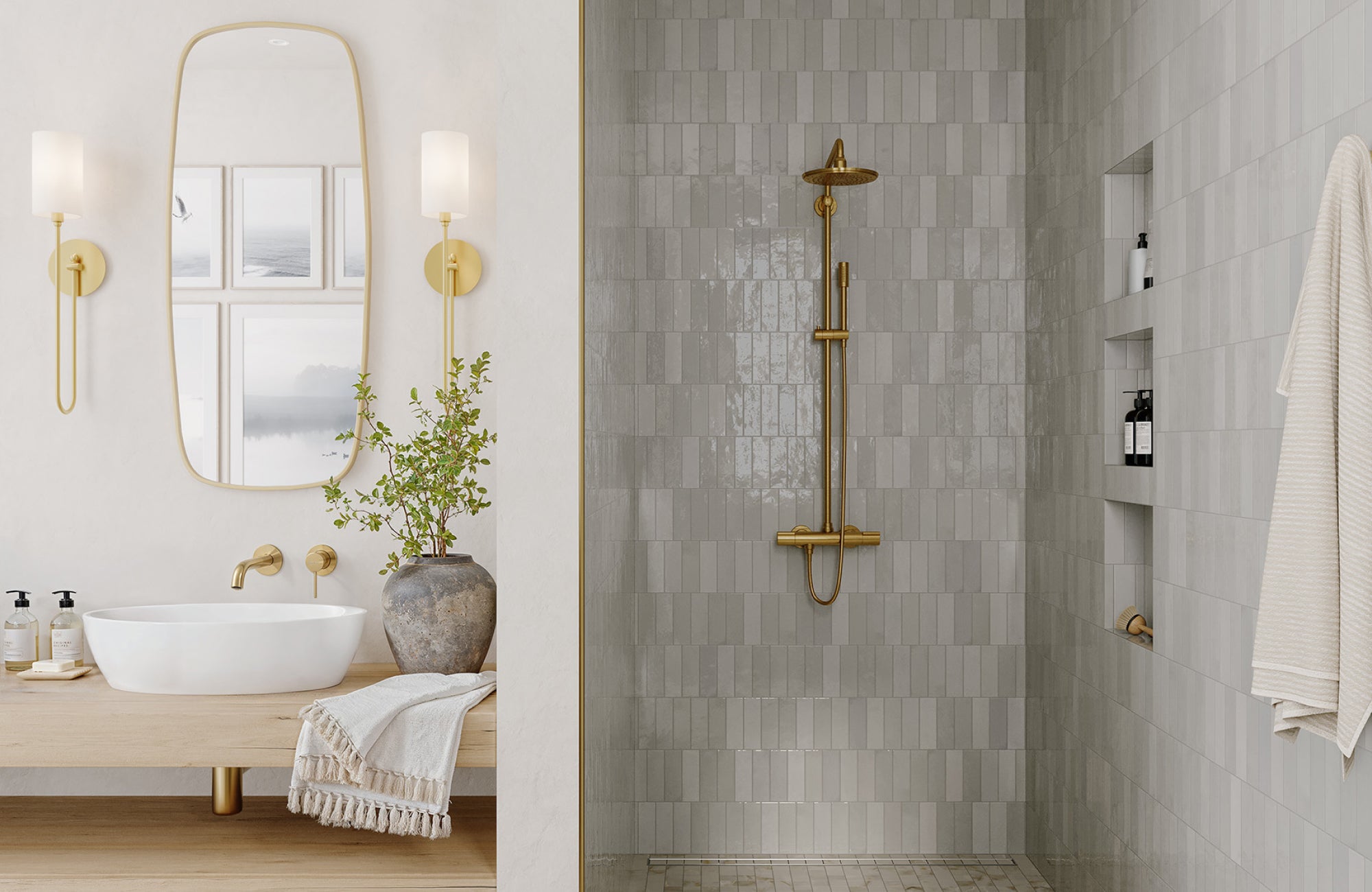 Wall sconces and shower fixtures in polished brass finish brighten a neutral bathroom with gray tile and a wood vanity.