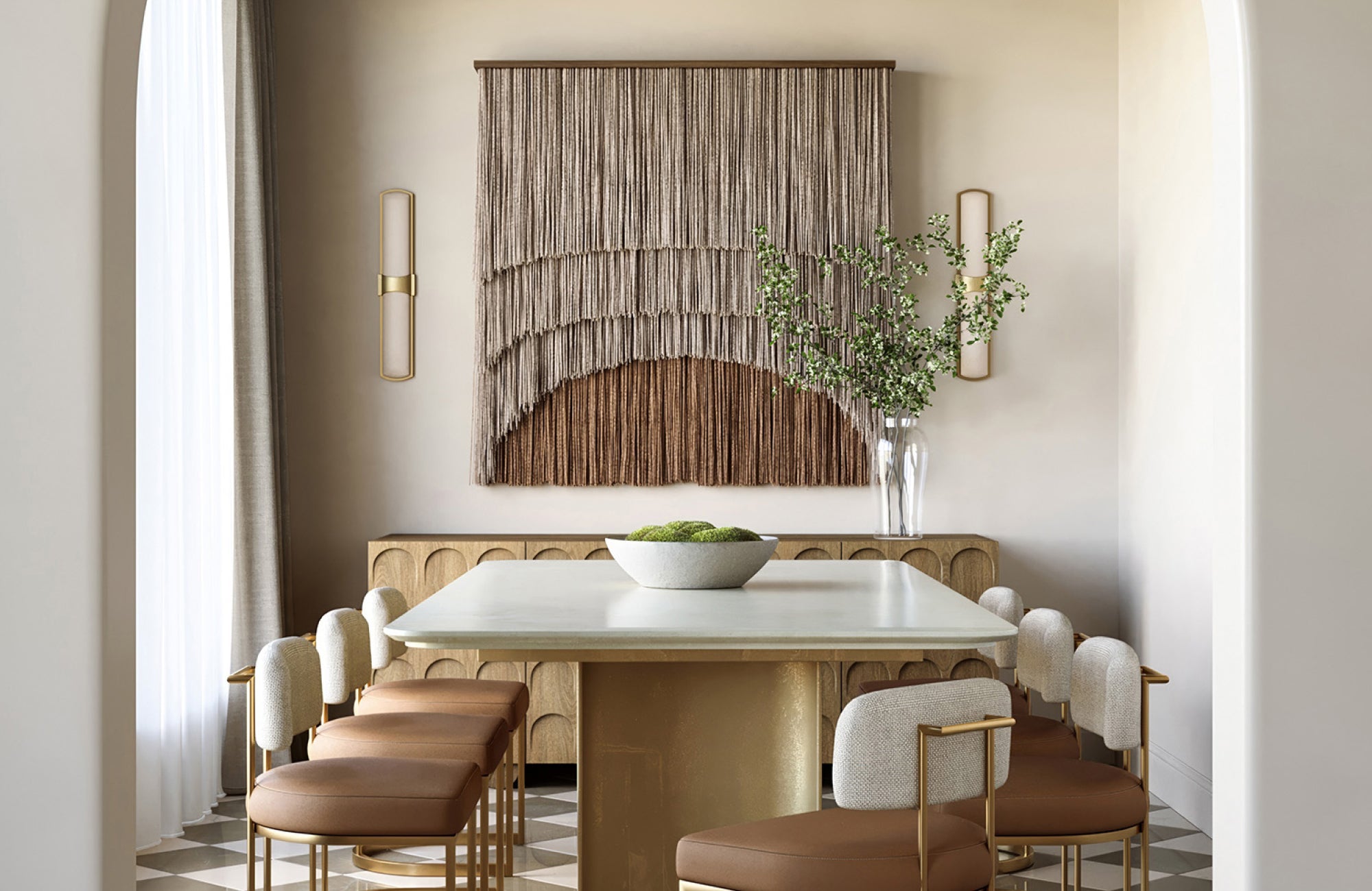 Slim brass wall sconces frame a woven wall hanging in a modern dining space, adding warmth and vertical balance.
