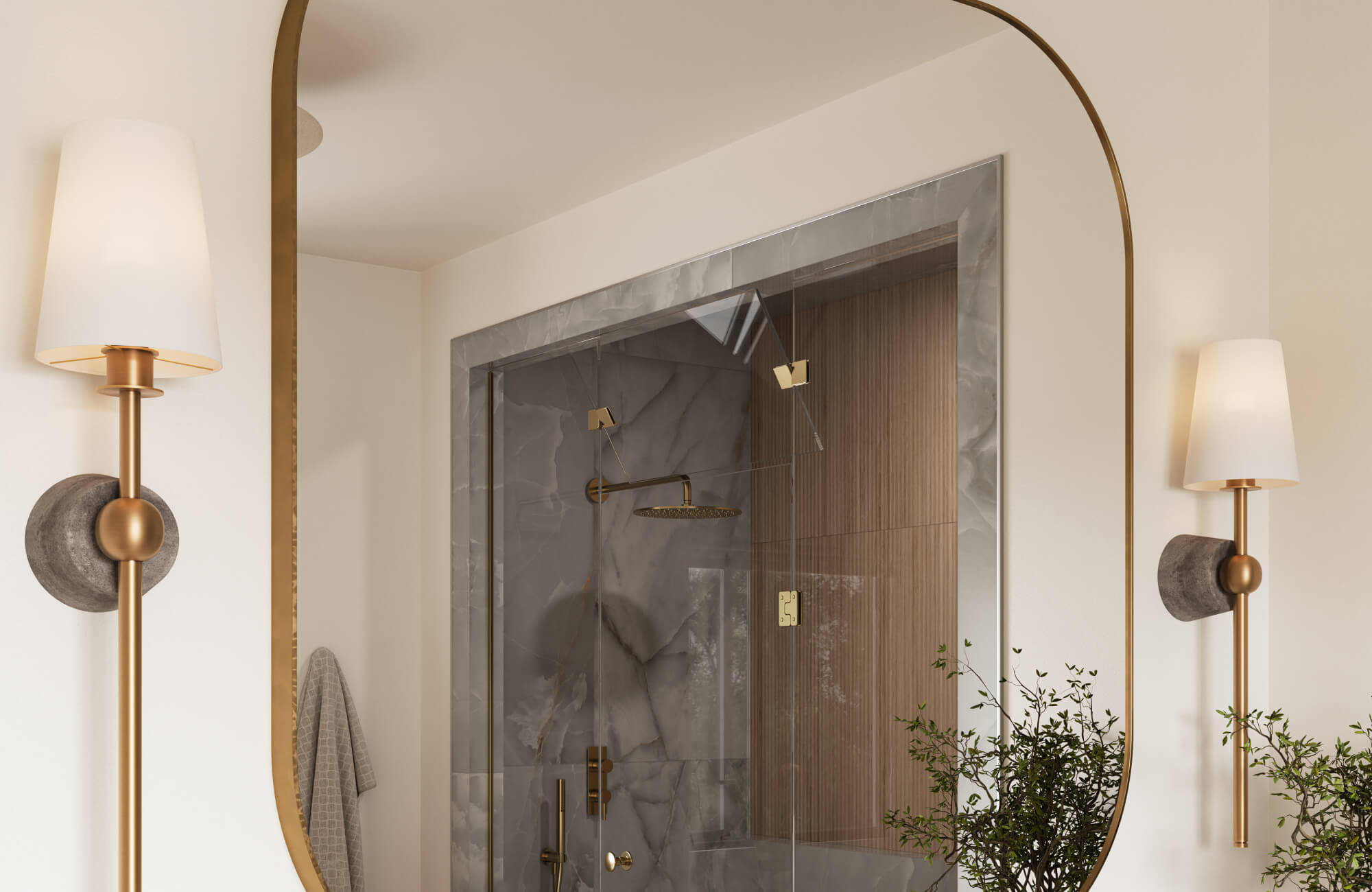 Modern bathroom with an arched brass framed mirror, flanked by wall sconces, reflecting a marble and wood shower.