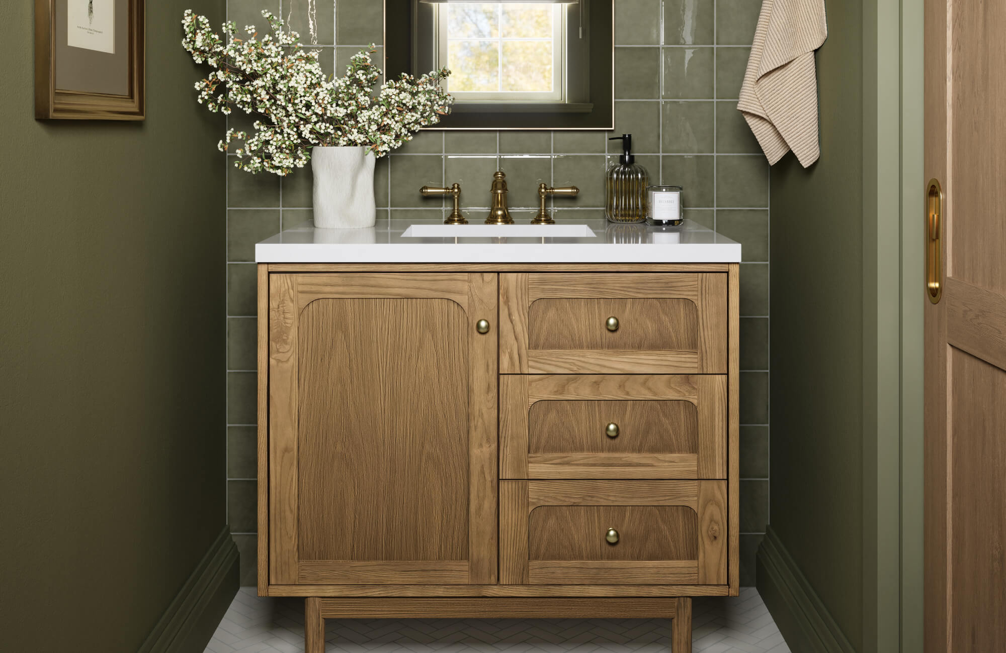null Natural wood vanity with paneled doors and drawers, framed by olive-toned walls and glossy tile, bringing warmth and structure to a narrow bathroom setting.