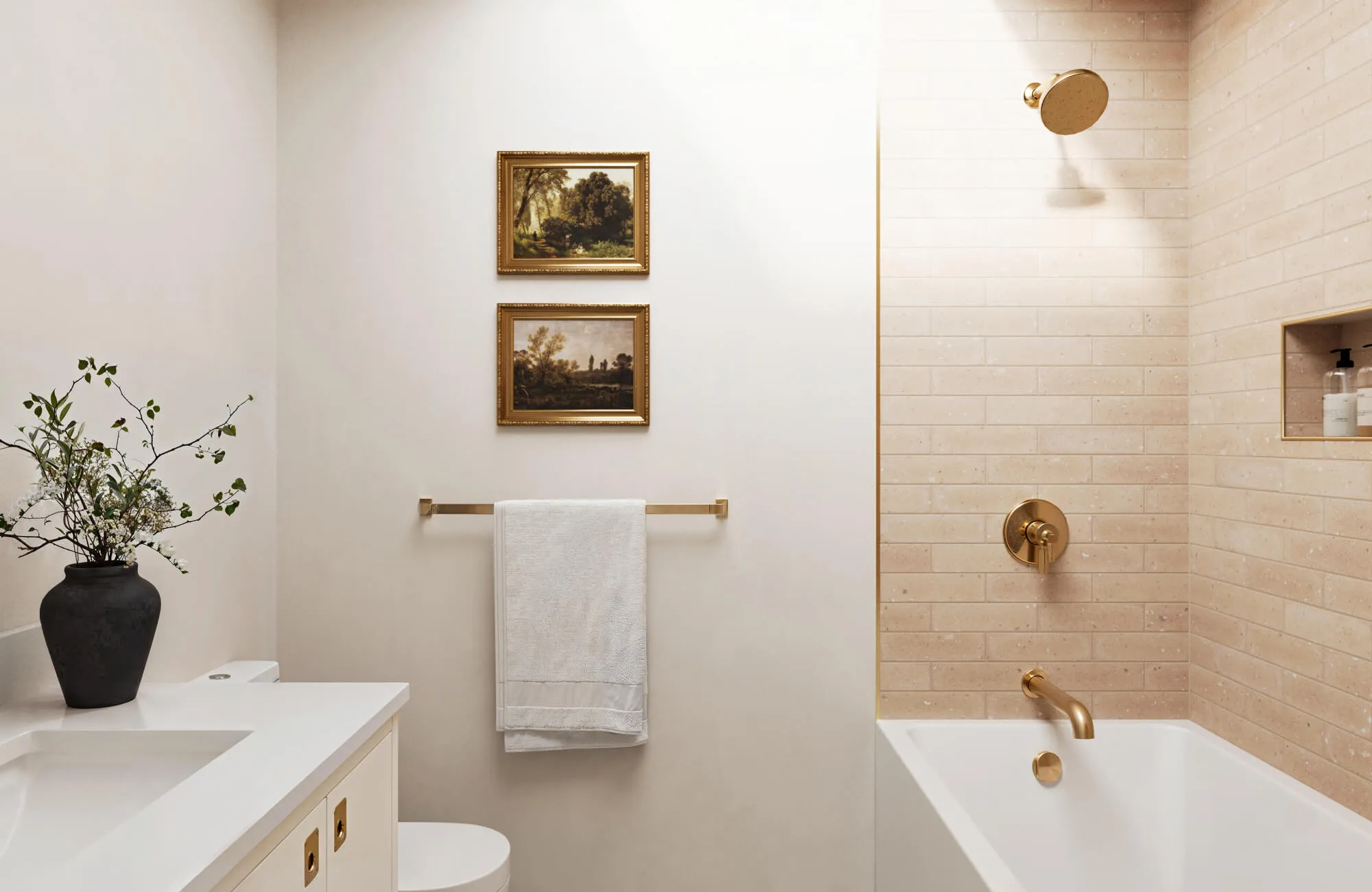 Bathroom with warm beige half-tiled bathtub walls, brass fixtures, framed wall art, and painted upper walls for a softer partial-tile layout.