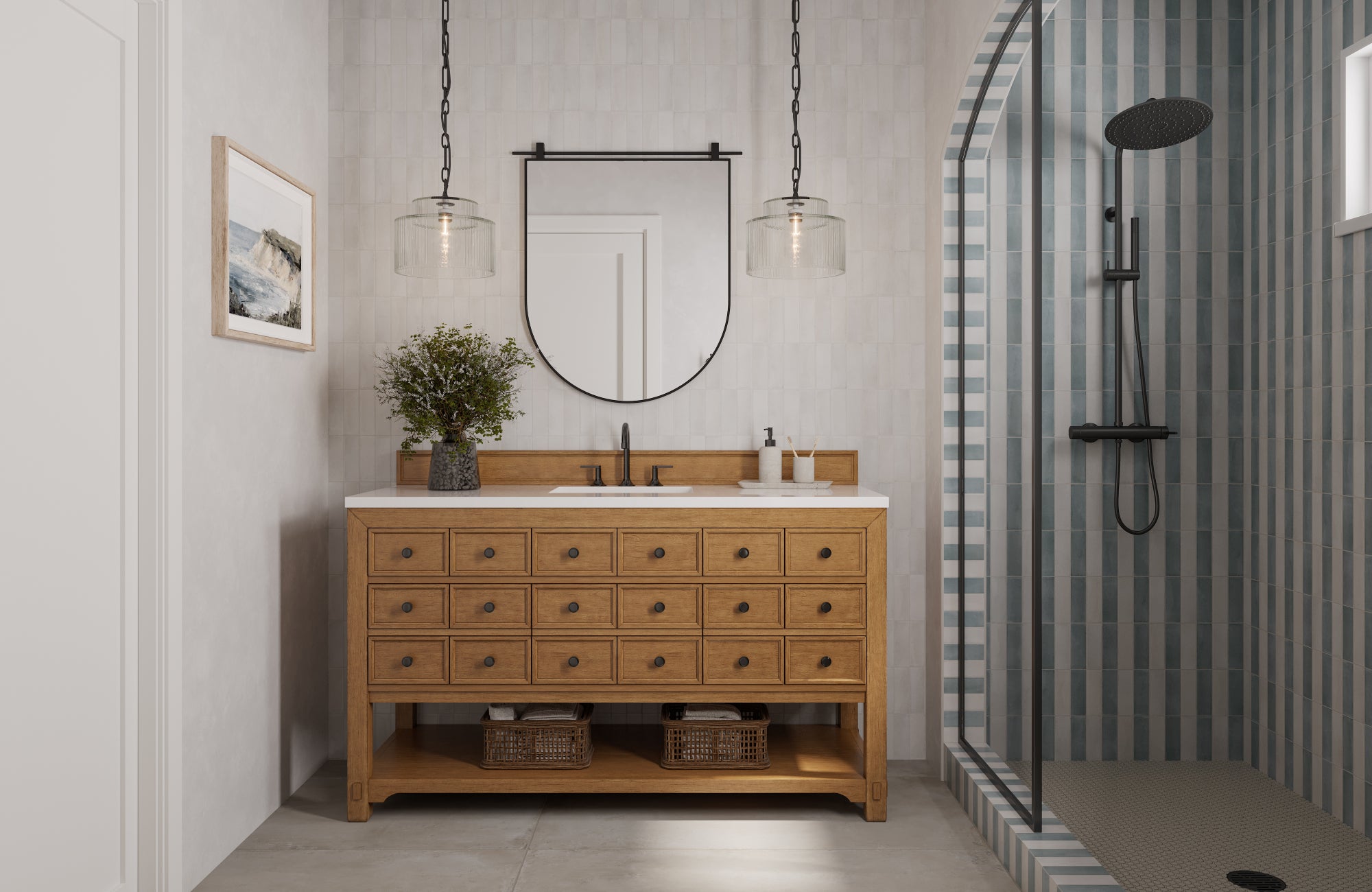 A natural wood bathroom vanity decorated with greenery and framed by pendant lights, complemented by a striped blue-and-gray tile shower with sleek black hardware.