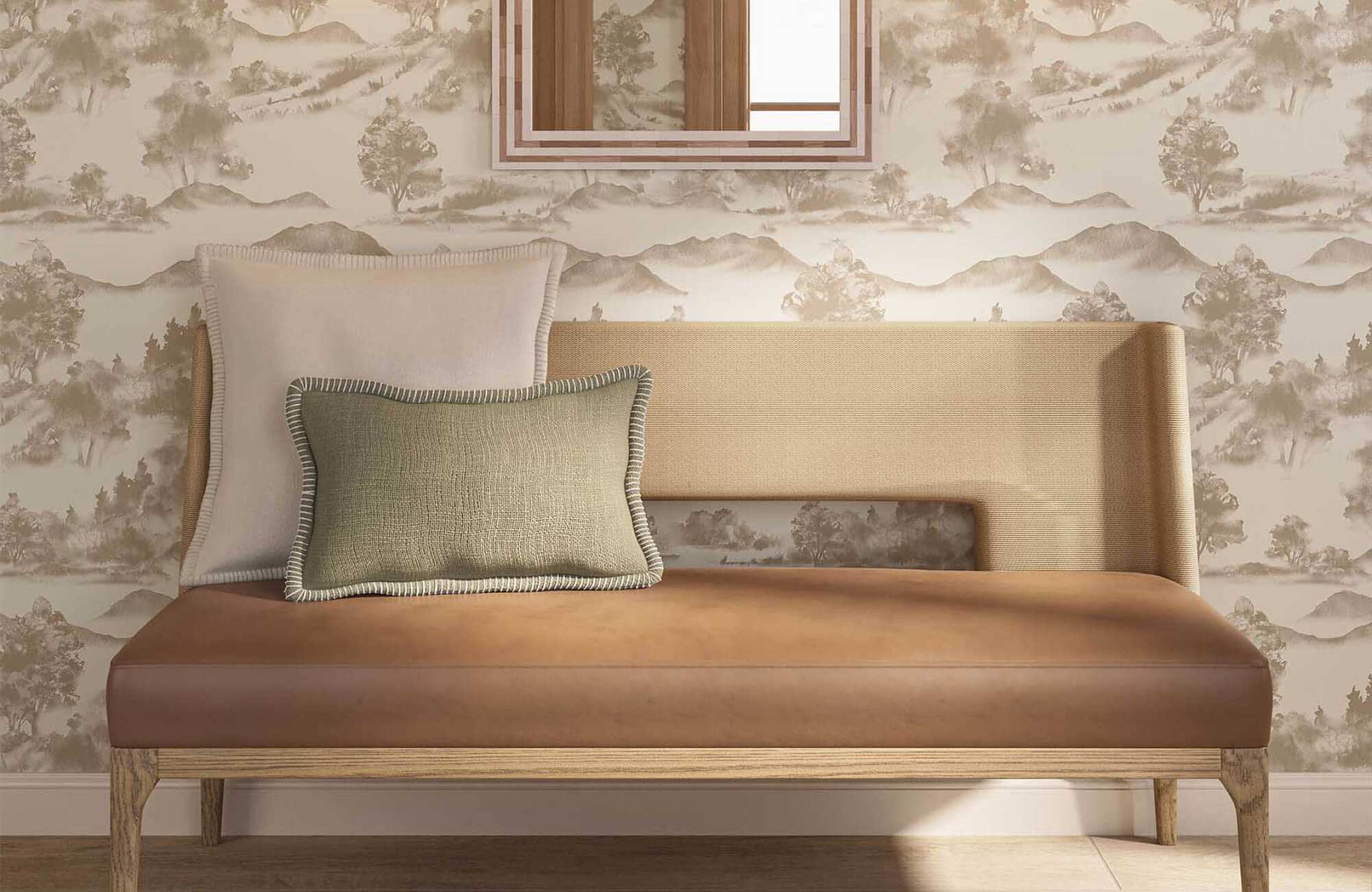 Upholstered bench with a brown leather seat, curved woven back, and two textured throw pillows set against scenic landscape wallpaper and a decorative wall mirror.
