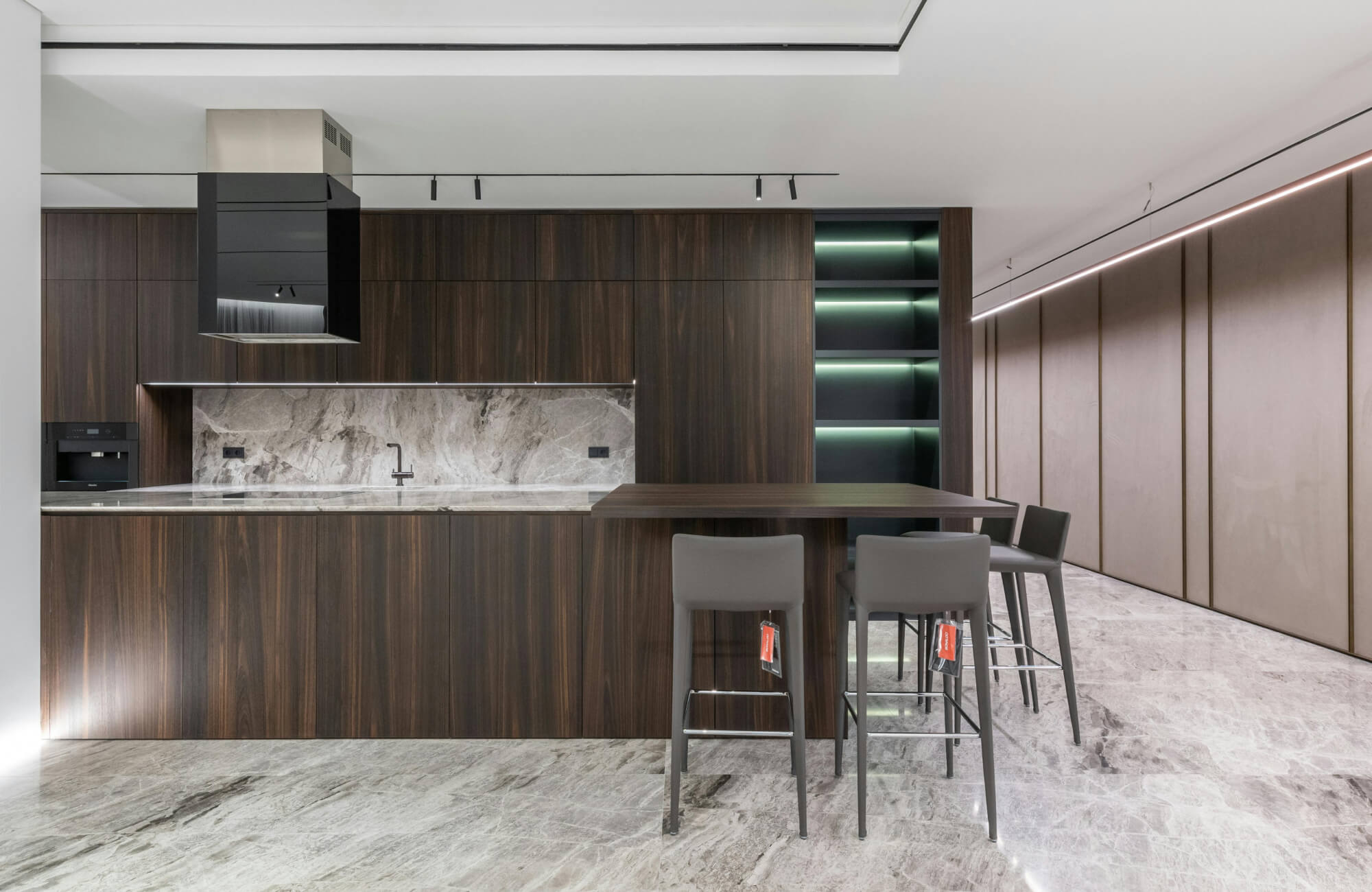 null Sleek modern kitchen with dark wood cabinetry, grey marble surfaces, and illuminated shelving.