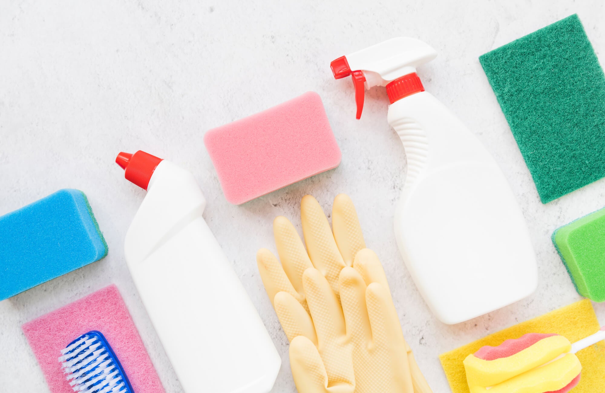 null Flat lay of colorful cleaning supplies including sponges, brushes, gloves, and spray bottles arranged on a light surface, symbolizing tile care and maintenance essentials.