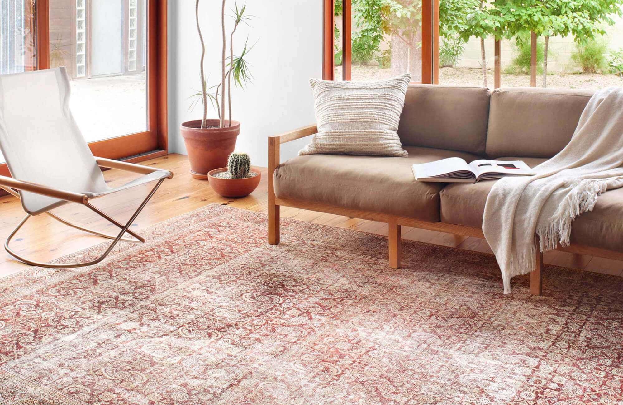 null Living room with a boho rug in muted red and cream shades, creating a warm, earthy foundation beneath neutral furniture.