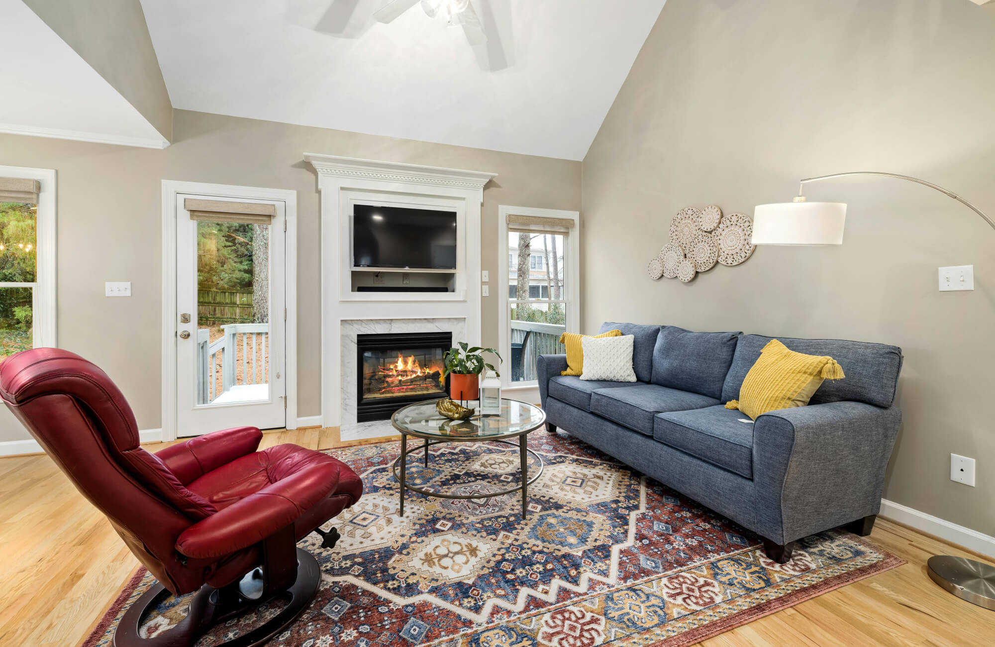 null Living room with a multicolor boho rug featuring red, blue, and beige patterns under cozy seating near a fireplace.