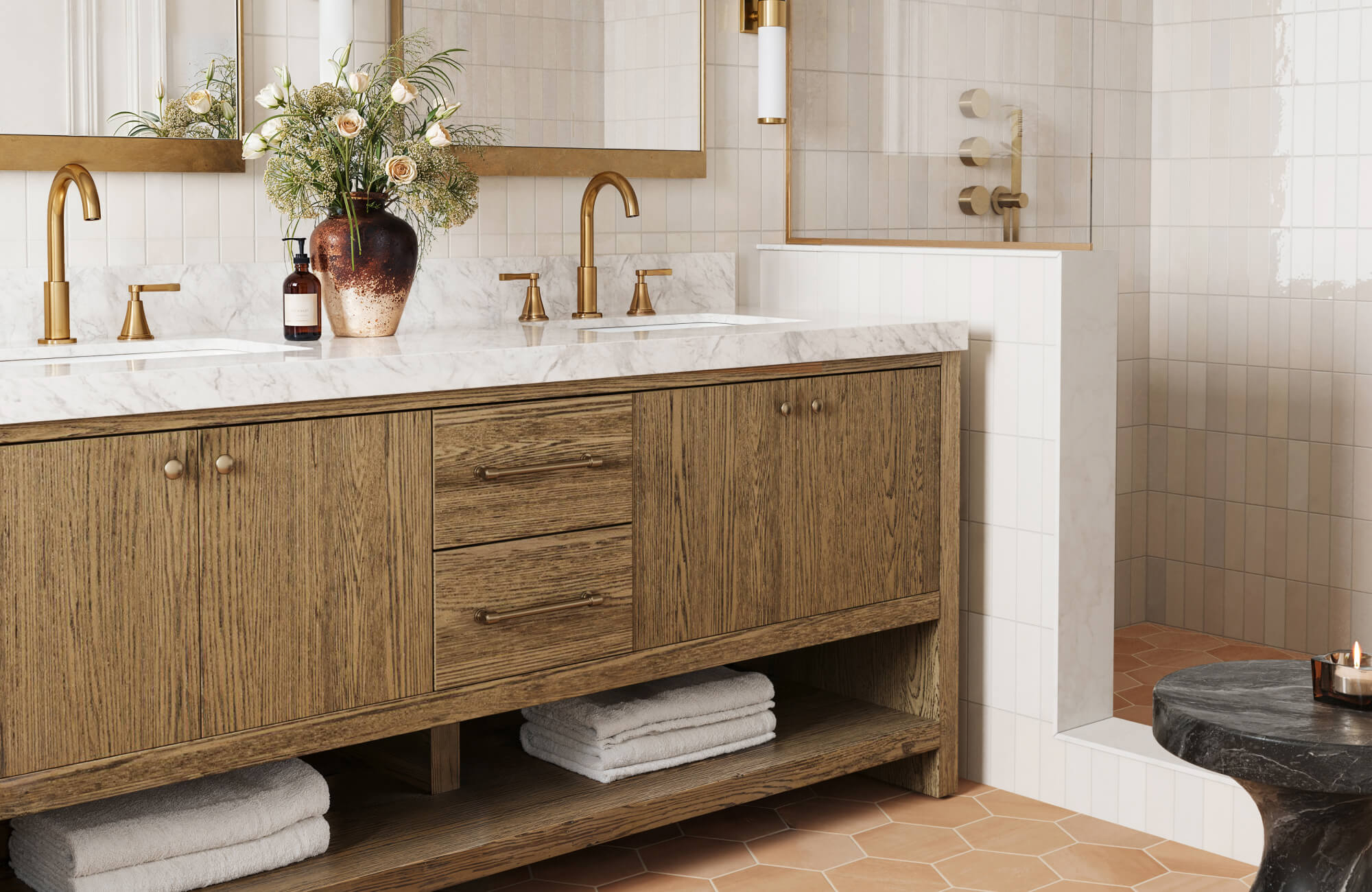 null Warm wood double vanity with marble top, brass fixtures, and soft ivory wall tiles in a spa-inspired setting.