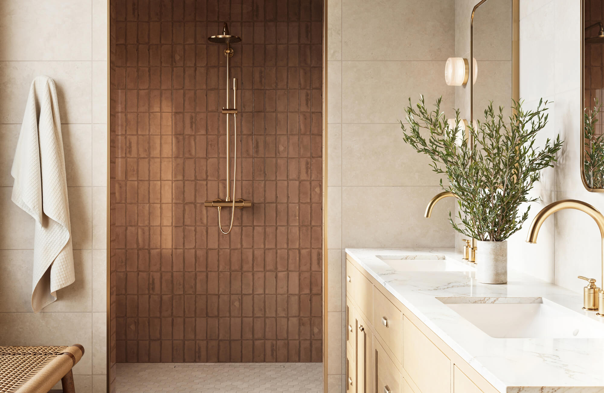 Elegant bathroom with brown tiled shower wall, brass fixtures, double vanity, and soft neutral tones for a warm look.