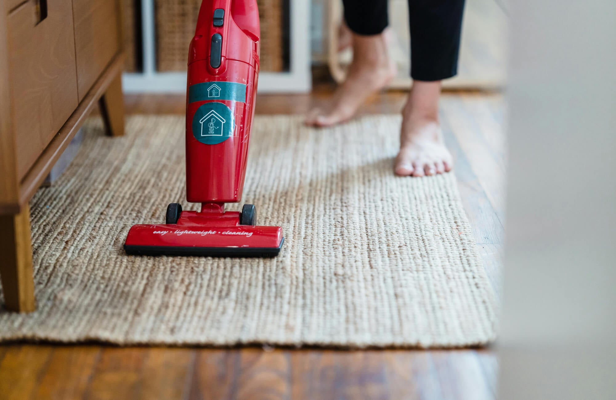 null Vacuum cleaning a wool natural fiber rug, illustrating its easy maintenance as the tightly woven fibers allow for simple upkeep while preserving texture and overall appearance.