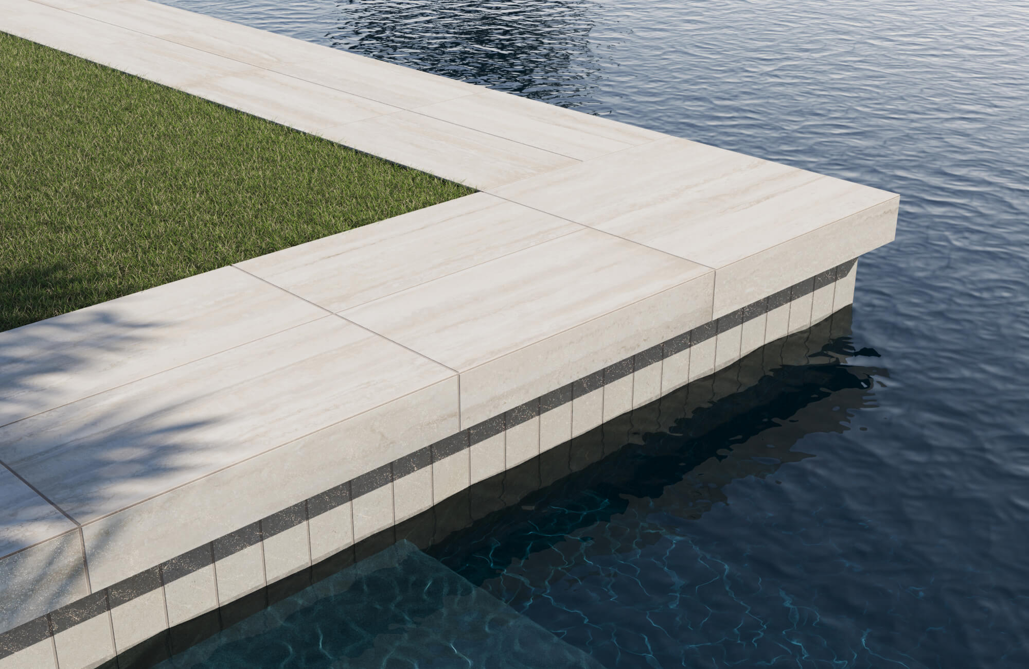 null Contemporary poolside design showcasing light beige stone-look paver tiles with clean edges, creating a seamless transition between the lush green lawn and the deep blue water for a refined, resort-style aesthetic.