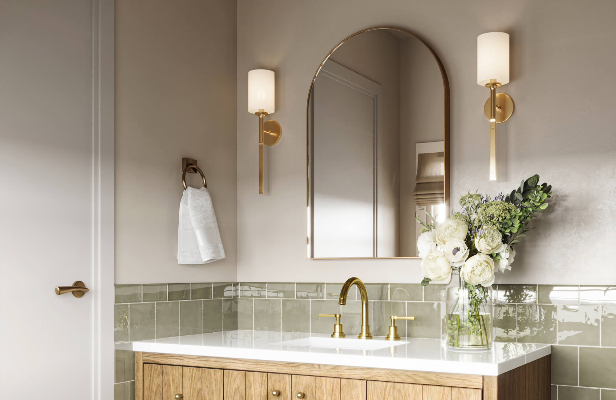 null Bathroom with sleek brass wall sconces, arched mirror, light oak vanity, and glossy sage green tile for balanced lighting and refined elegance