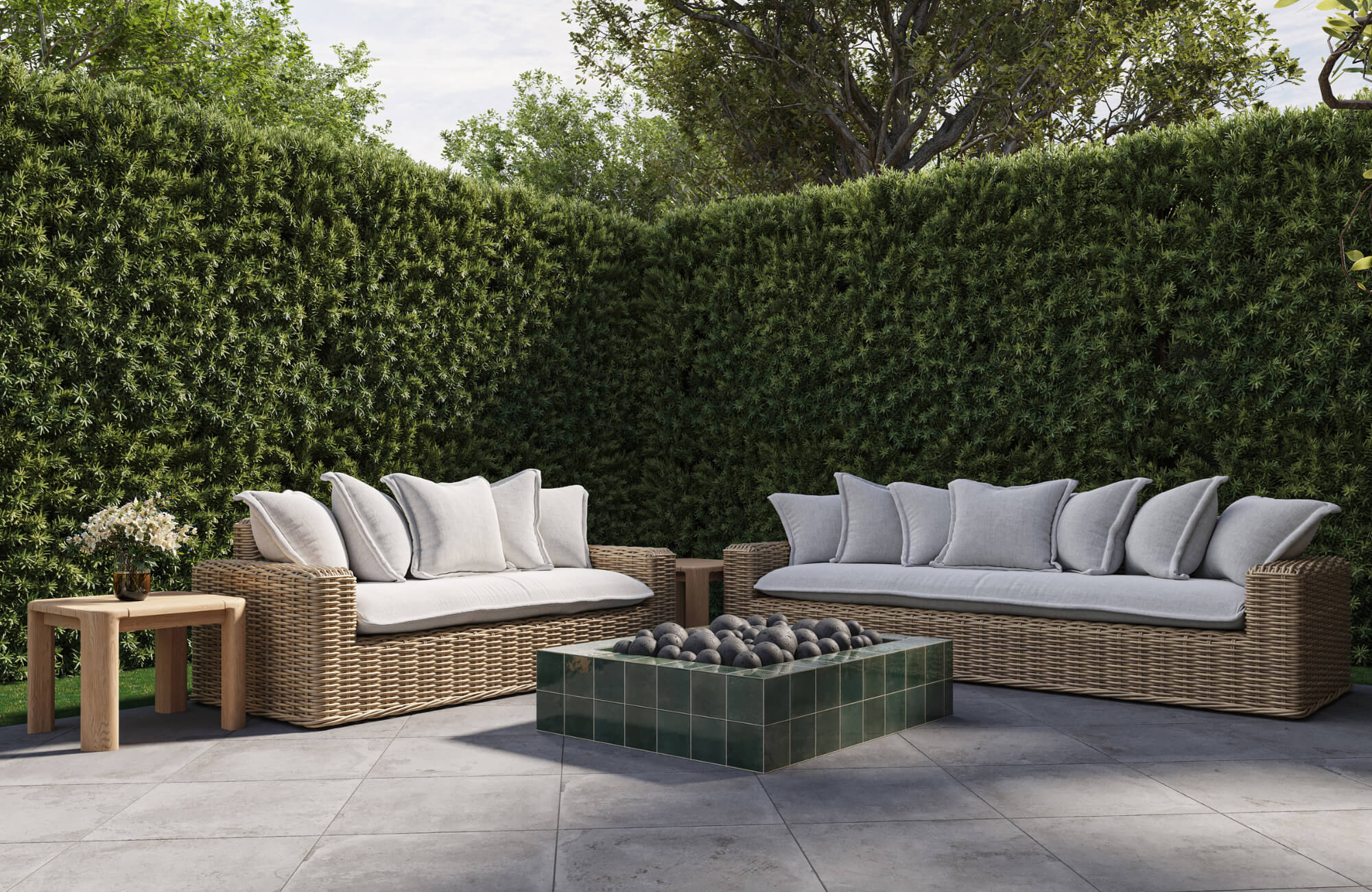 null Outdoor wicker lounge seating arranged around a tiled fire pit with tall hedges creating a secluded patio gathering retreats.