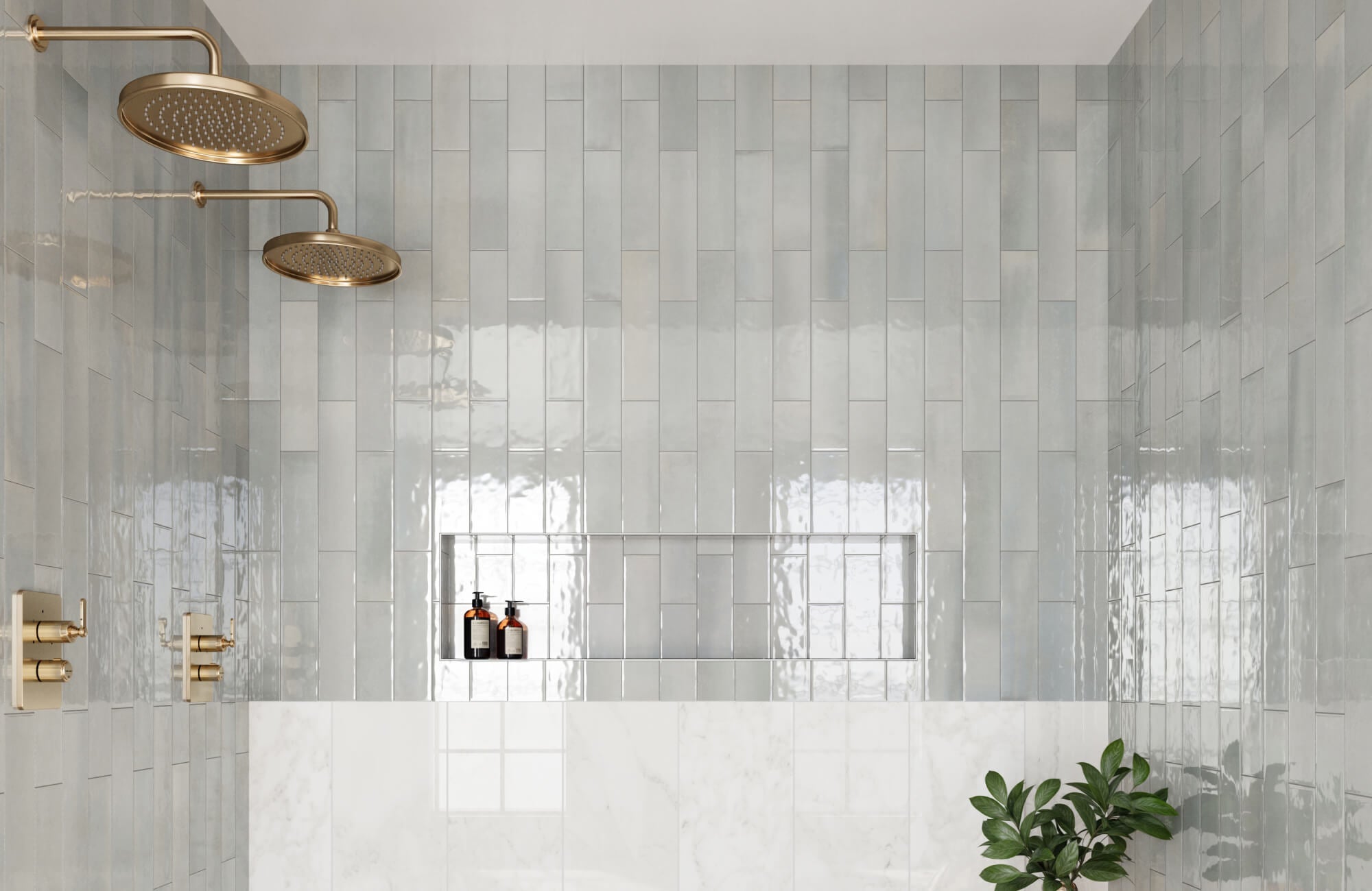 Glossy light blue shower subway tiles installed in a vertical offset pattern reflect natural light beautifully, while brass fixtures and a built-in niche contribute to the shower’s sleek, spa-like ambiance.
