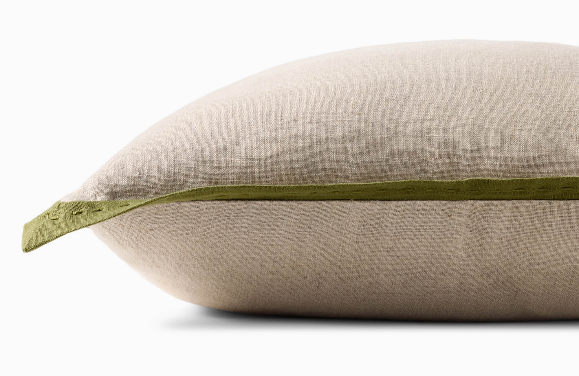 null Close-up of a decorative pillow with linen fabric and green accent trim, highlighting material-based pillow types and subtle textural variation.