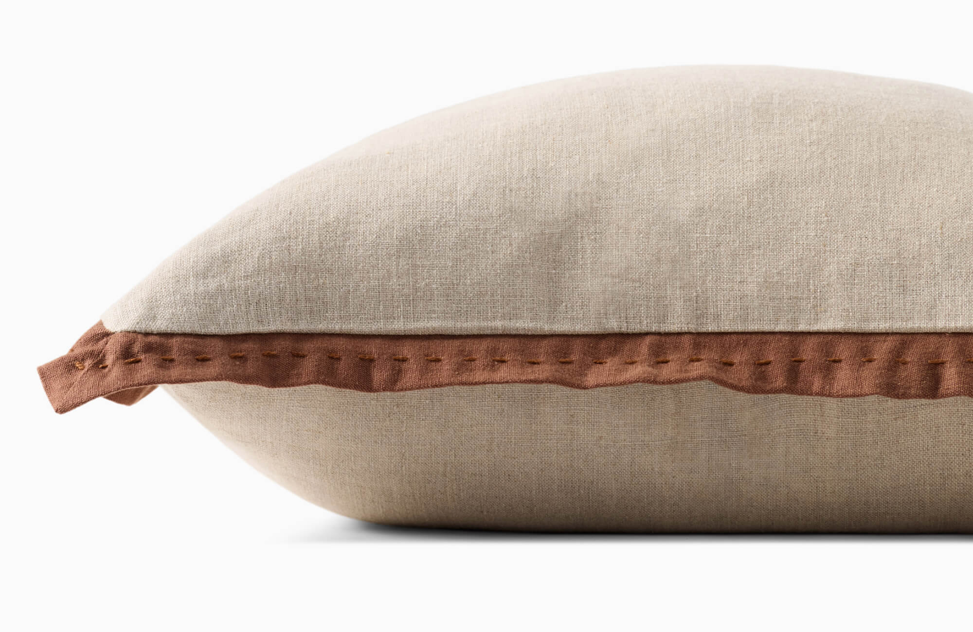 null Close-up of a decorative pillow with linen fabric and brown stitched edge detail, emphasizing fabric choice and how texture defines pillow style.