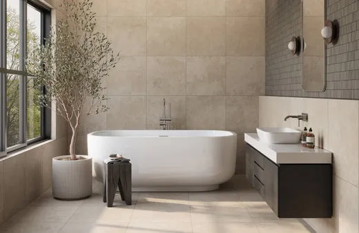 Modern bathroom with large beige wall and floor tiles surrounding a freestanding tub, complemented by a wood vanity and natural accents for a warm neutral look.