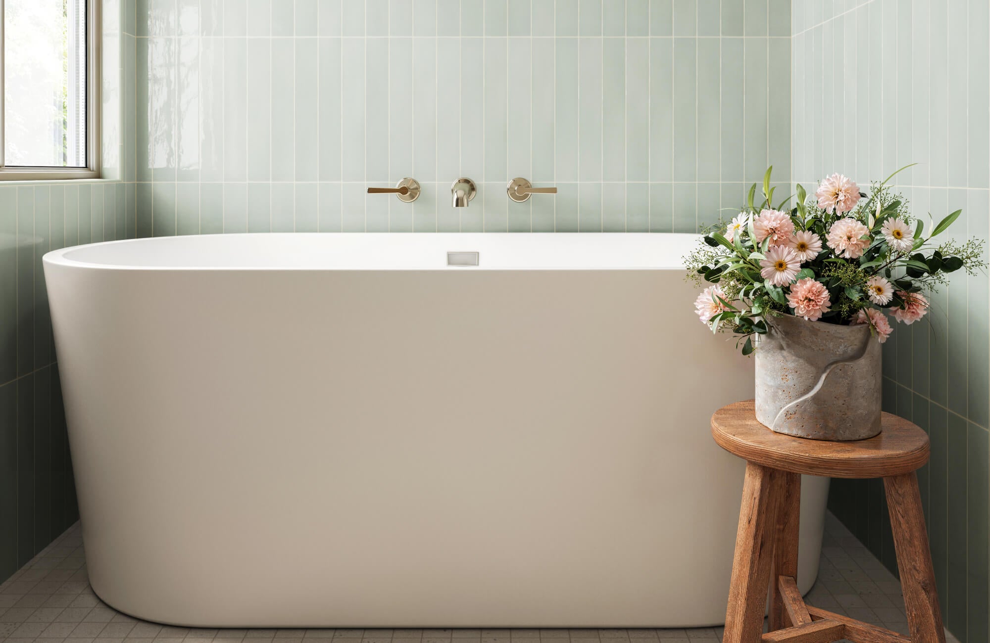 null Soft green wall tiles behind a freestanding tub, creating a fresh and calming bathroom.