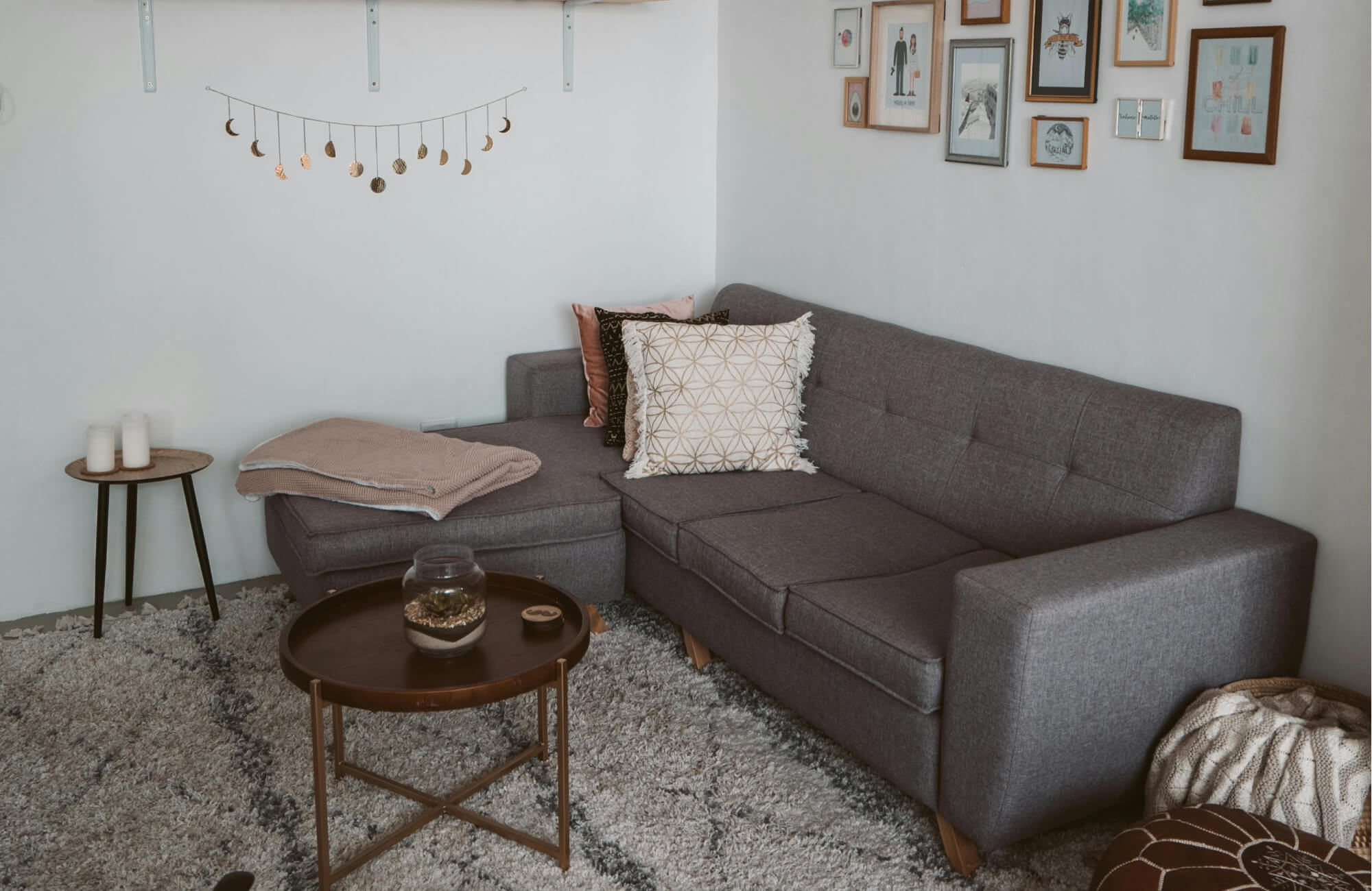 null Cozy living room with textured gray floor tiles, modern sectional sofa, and decorative pillows in warm neutrals.