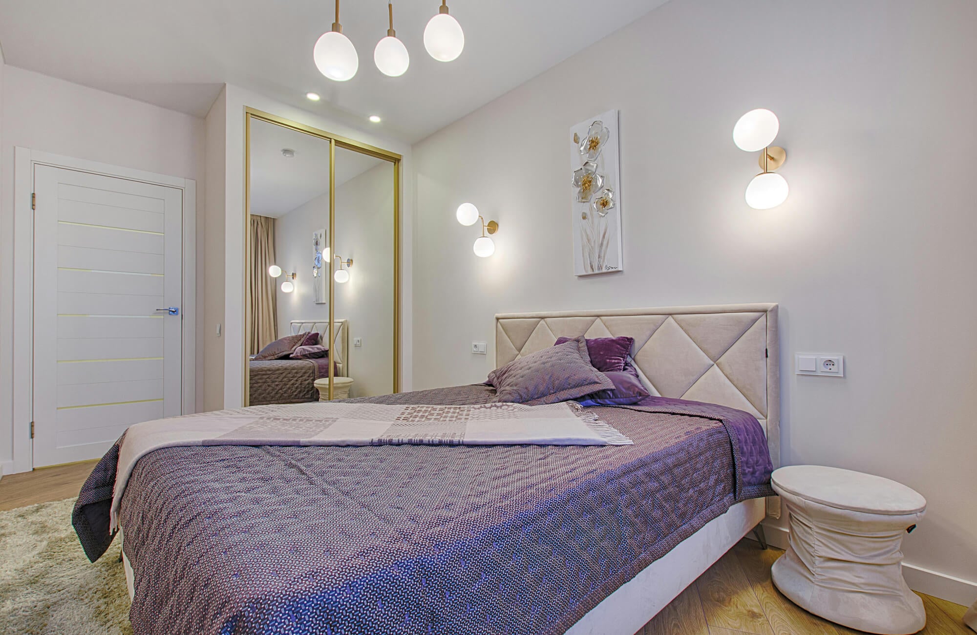 null Contemporary bedroom with light wood look floor tiles, tufted headboard, and decorative pillows in soft neutrals.