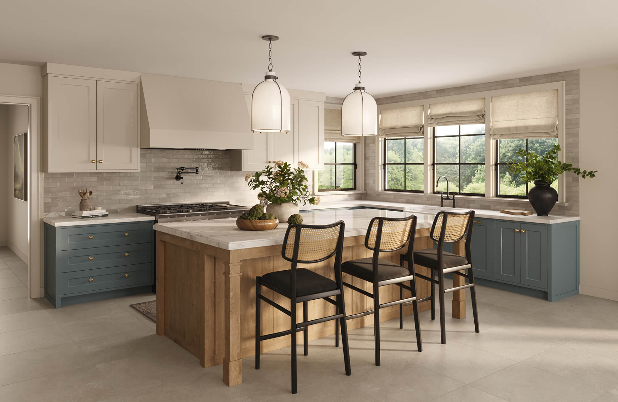 Tall cylindrical pendants suspended above a two-tone kitchen island, creating even illumination across the surface.