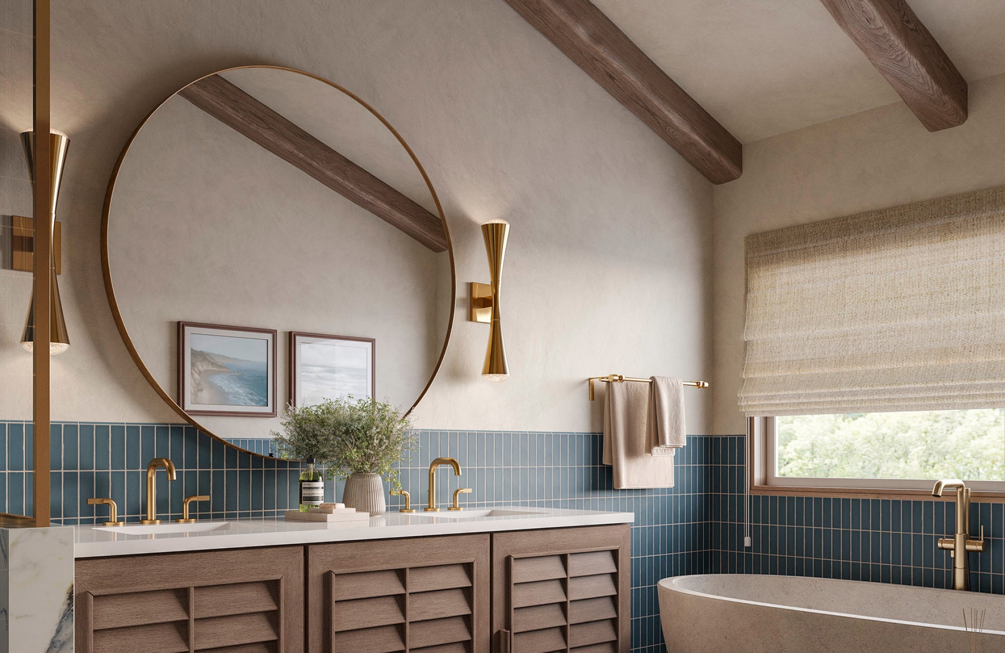 Large round bathroom mirror with thin brass frame, centered over a double sink and paired with sculptural wall sconces.