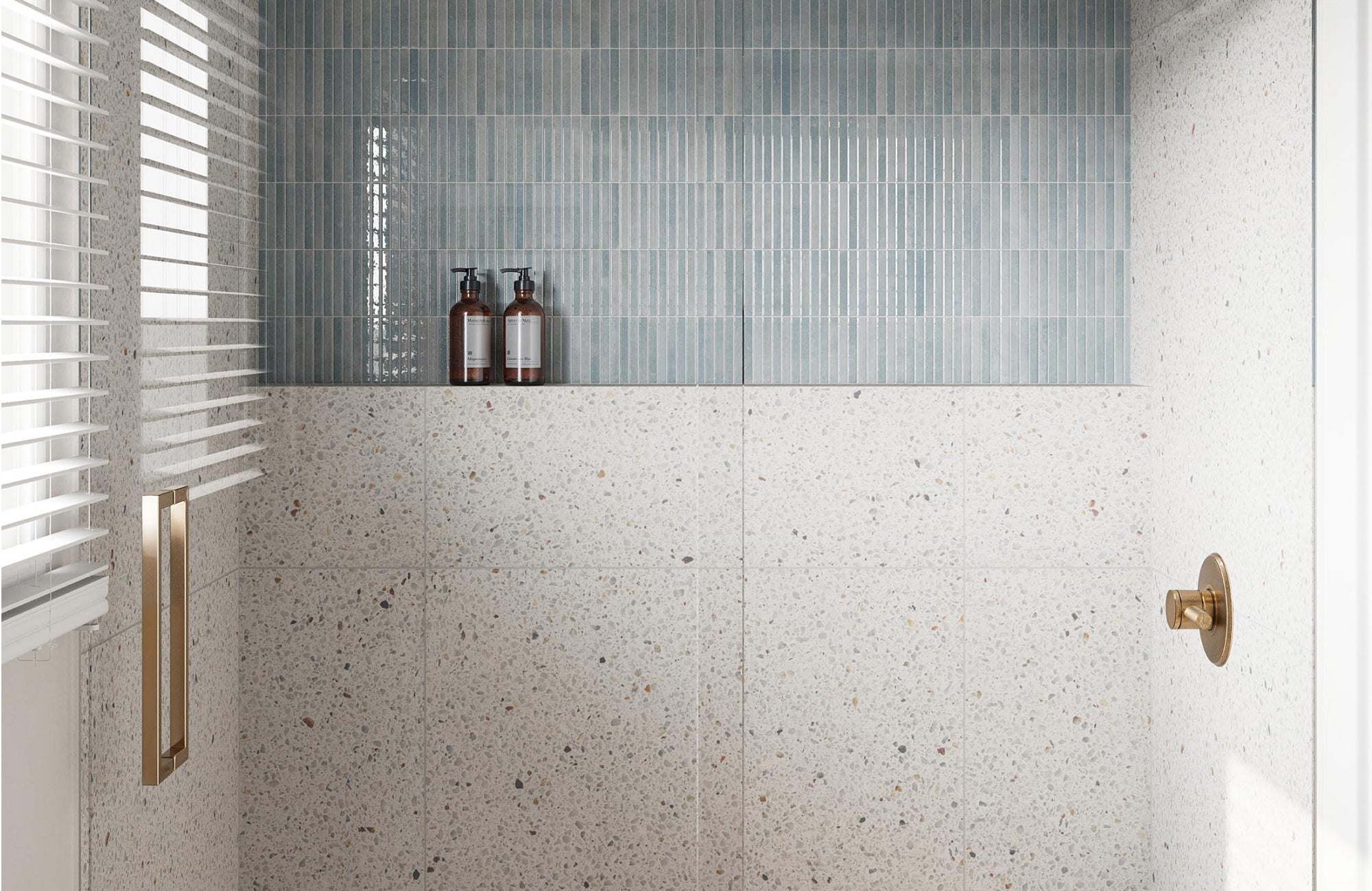 Muted blue-green shower tiles paired with terrazzo-look walls, creating a serene and textured contemporary space.