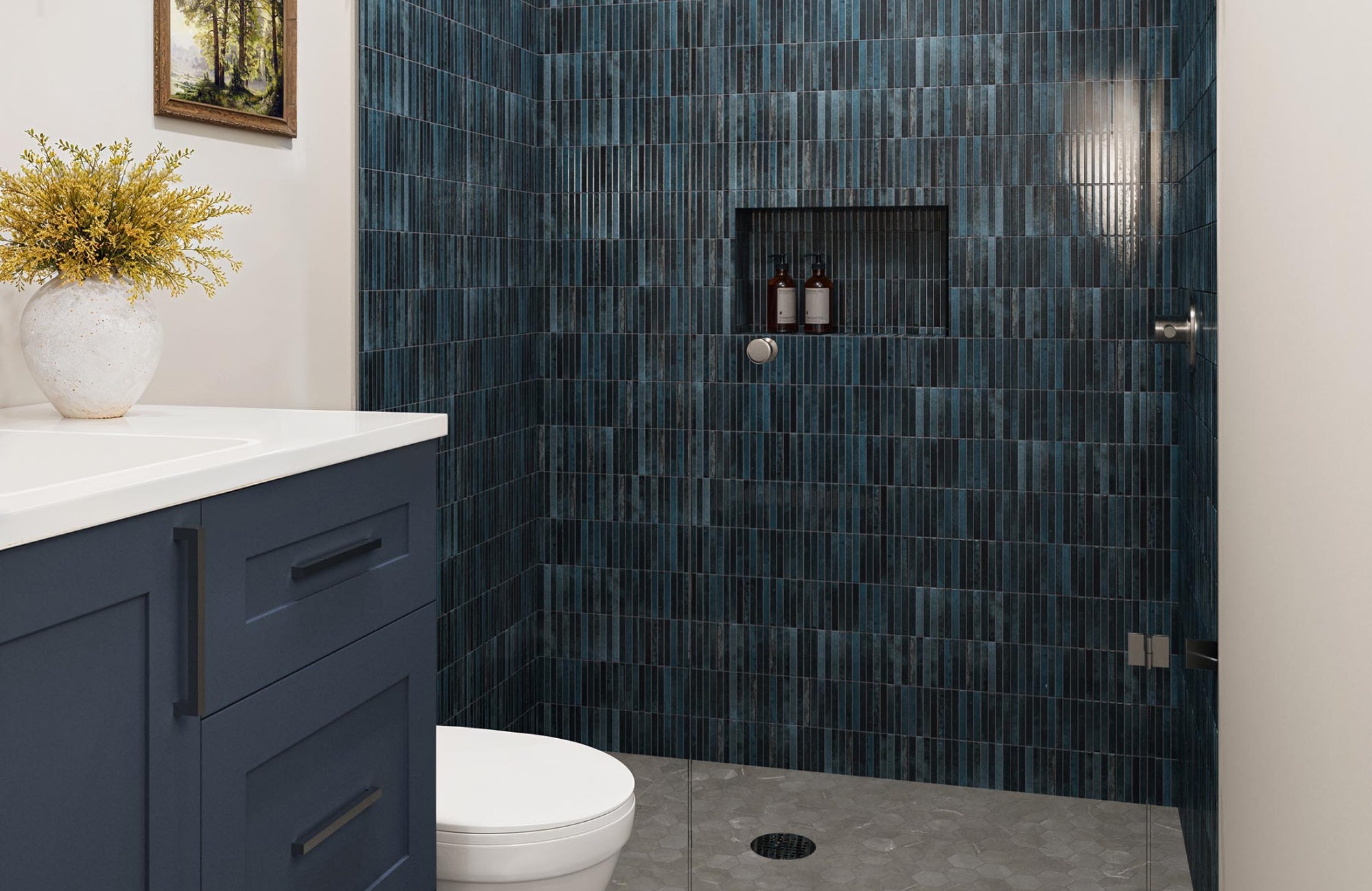 Navy shower tiles and navy vanity with gray flooring, showing a bold blue-on-blue scheme balanced by soft neutral surfaces.