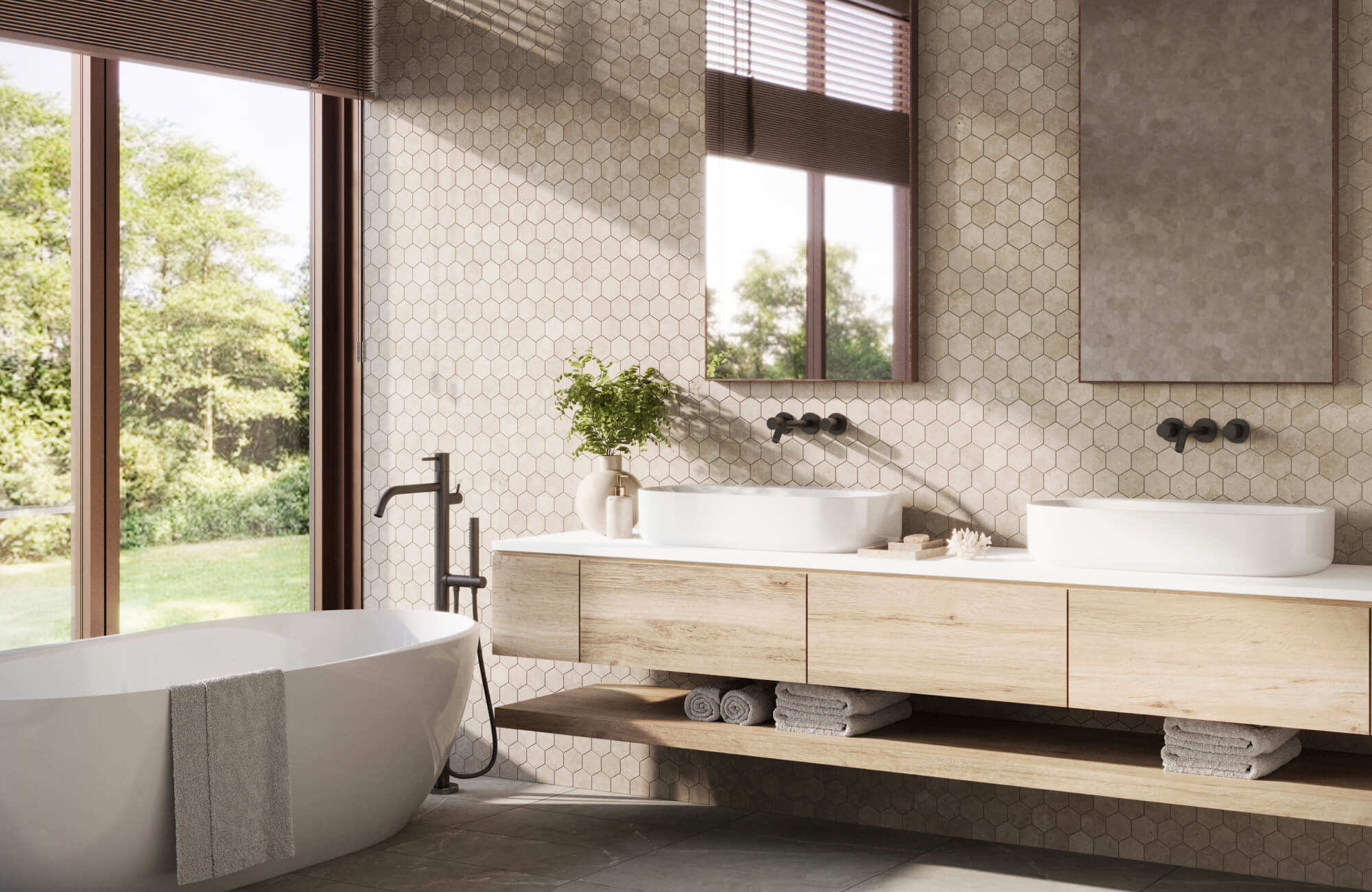 A modern bathroom with beige hexagonal tiles, a floating wood vanity, two rectangular mirrors, a freestanding tub, and large windows bringing in natural light.